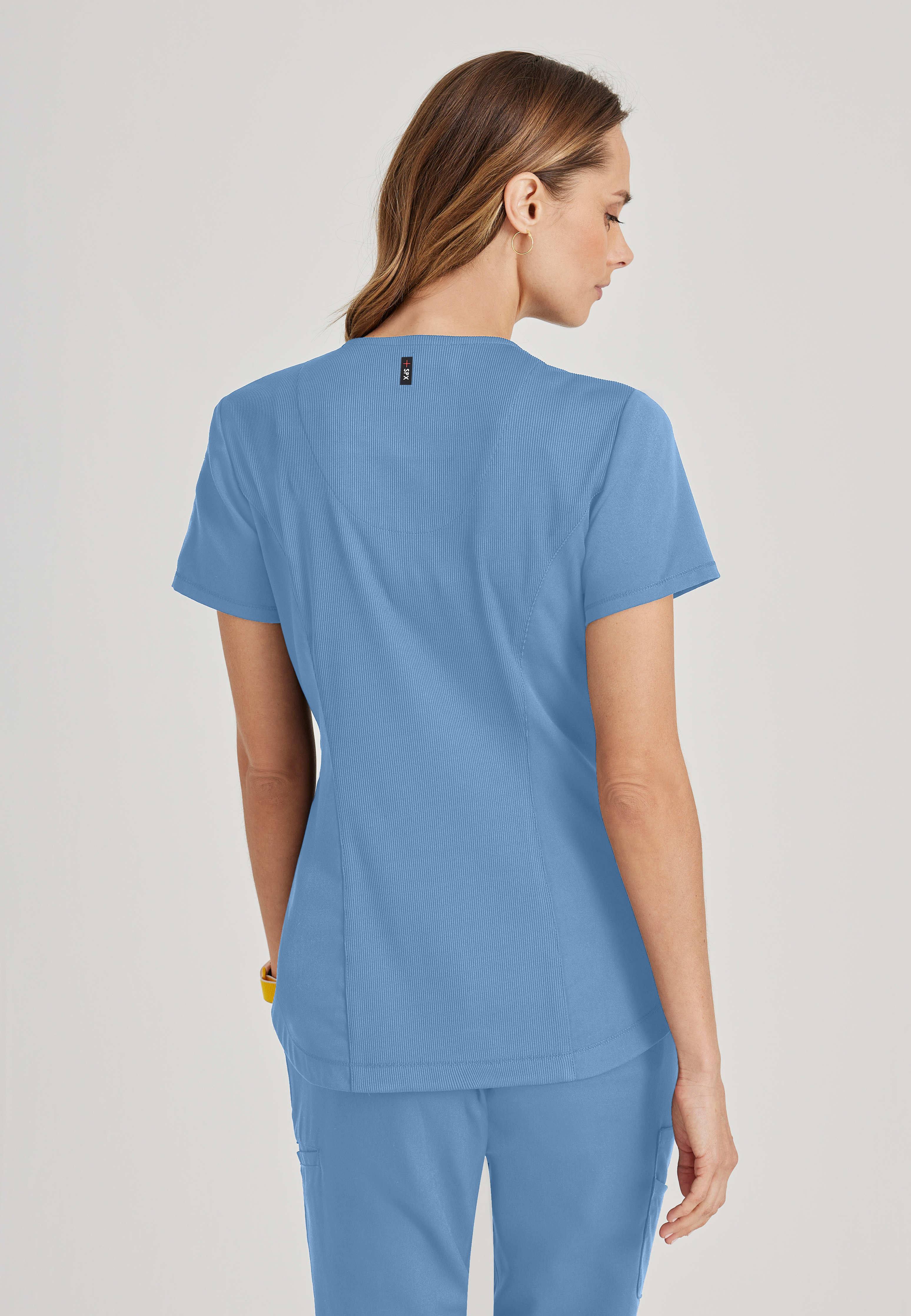 Side View of the Capri 2-Pocket Hourglass V-Neck Scrub Top in Ciel Blue from Grey's Anatomy™ by Barco Spandex Stretch