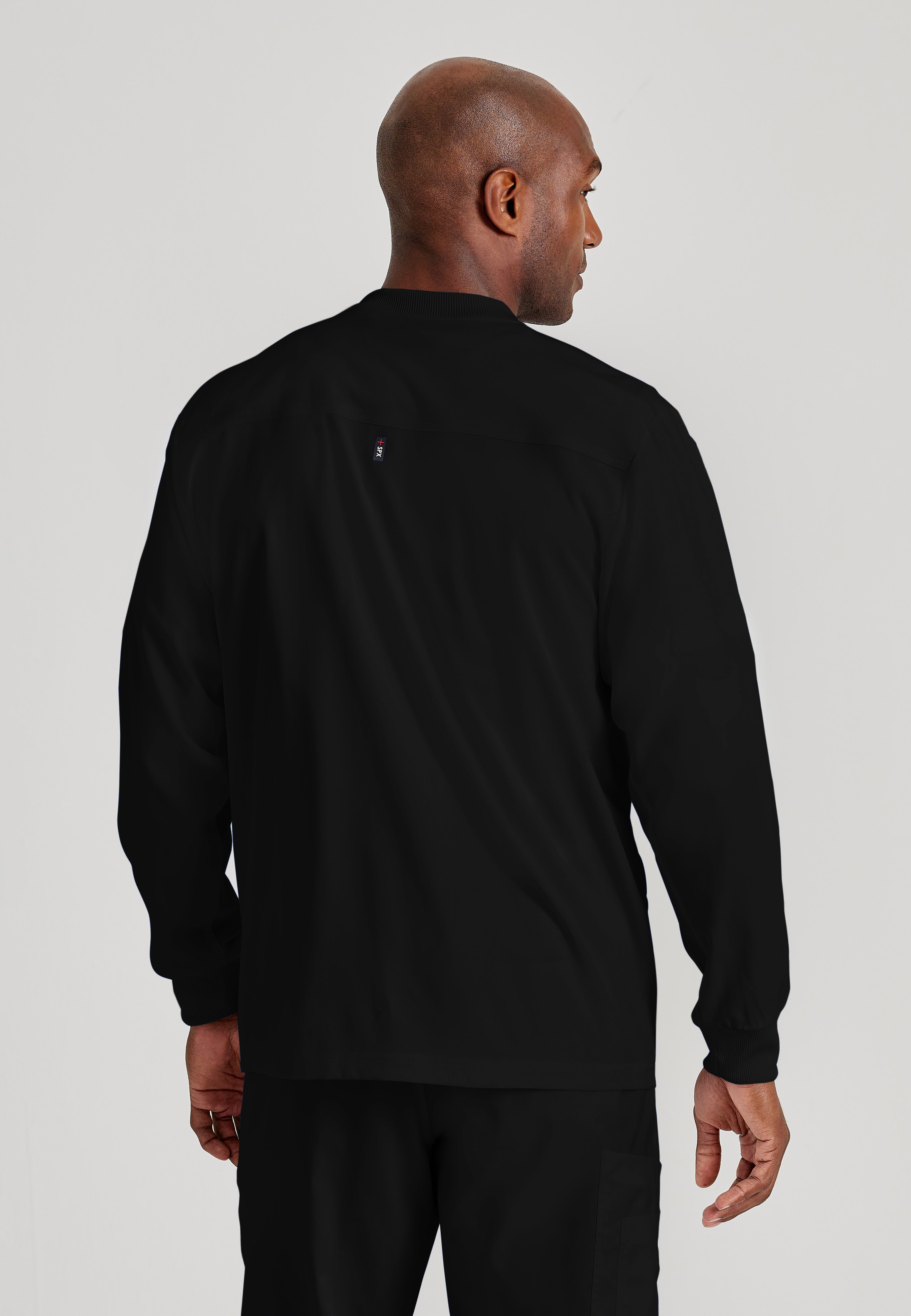 Back View of the React 5-Pocket Crewneck Warmup Scrub Jacket in Black from Grey's Anatomy™ by Barco Spandex Stretch