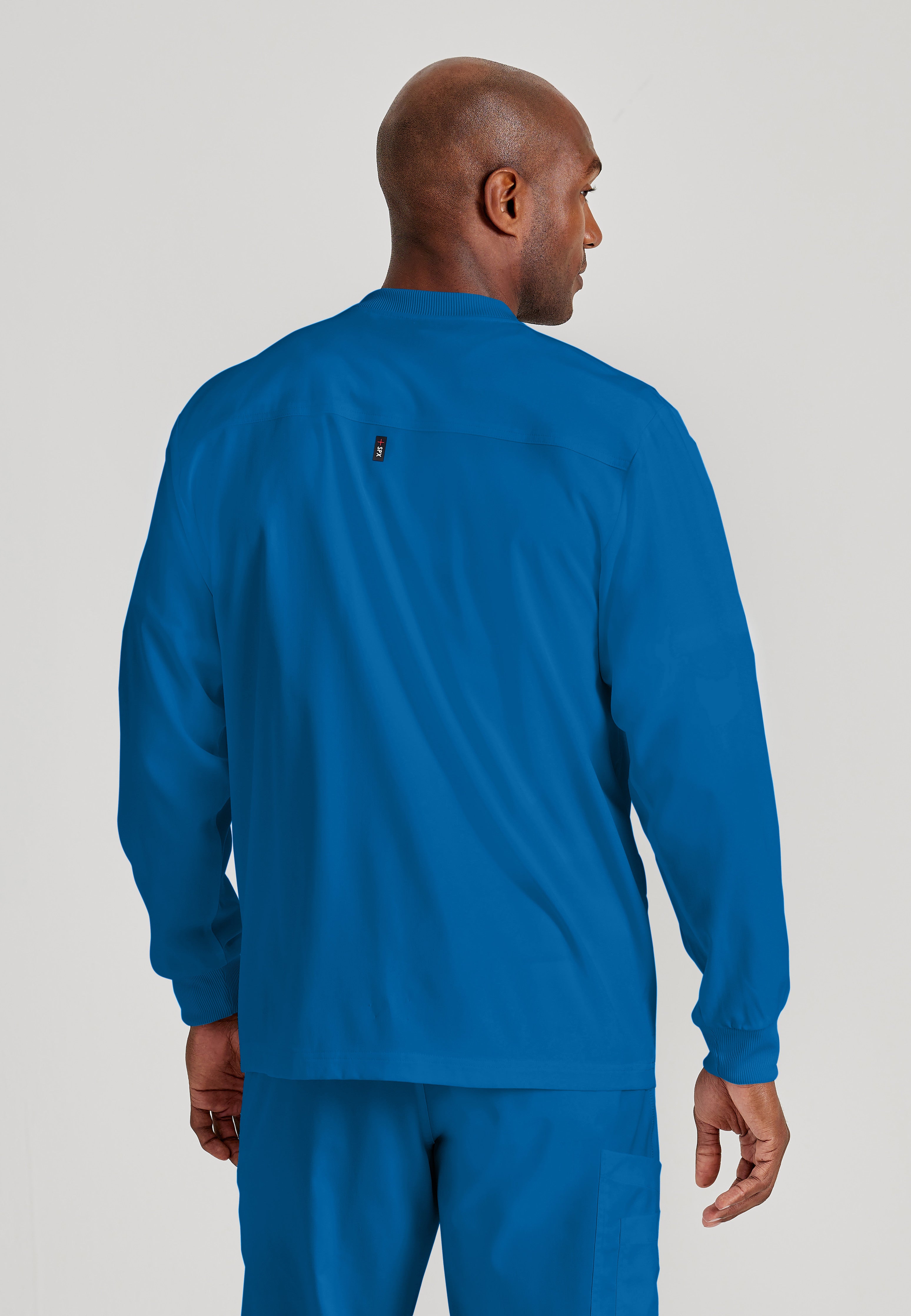 Back View of the React 5-Pocket Crewneck Warmup Scrub Jacket in New Royal from Grey's Anatomy™ by Barco Spandex Stretch