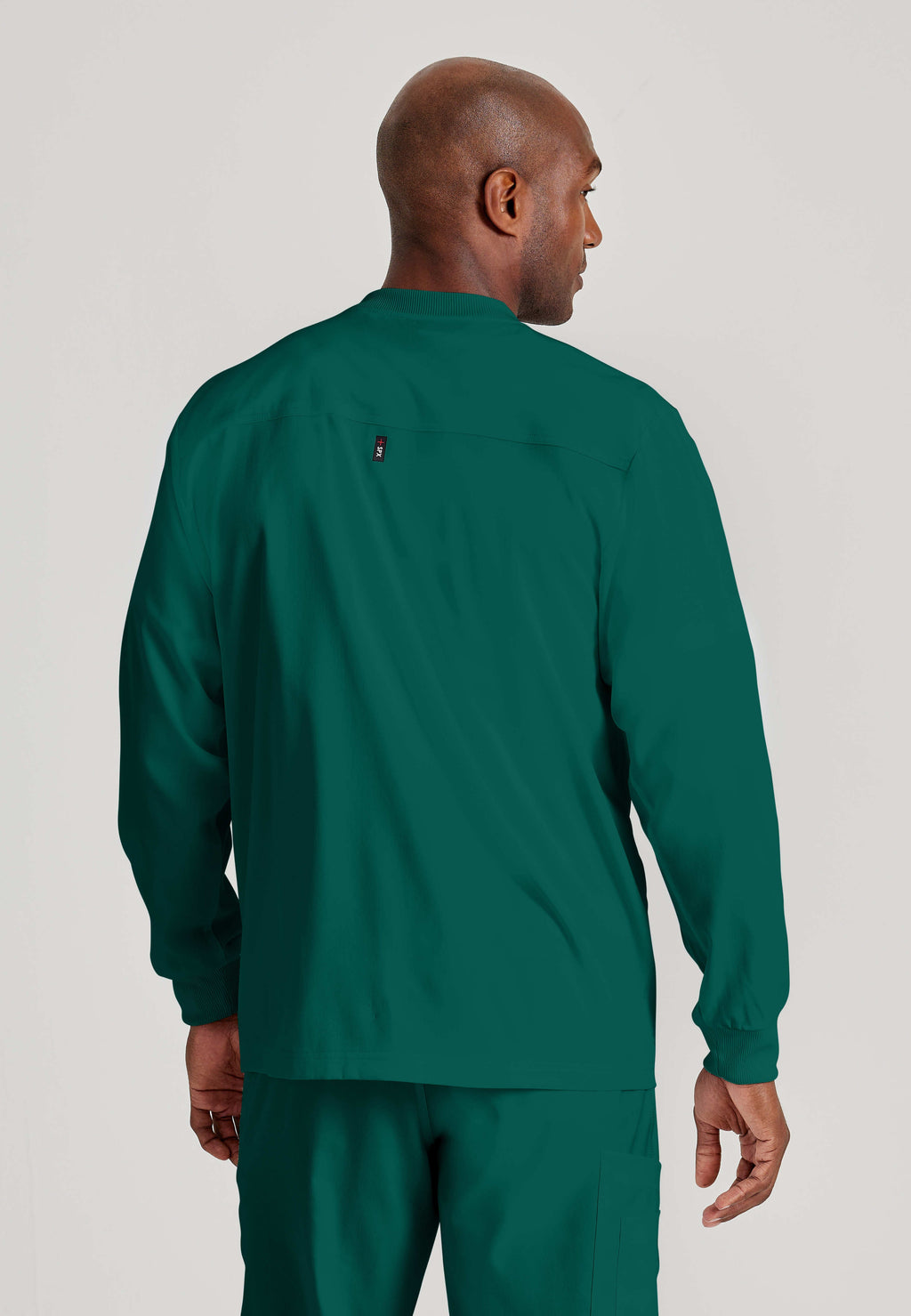 Back View of the React 5-Pocket Crewneck Warmup Scrub Jacket in Hunter Green from Grey's Anatomy™ by Barco Spandex Stretch