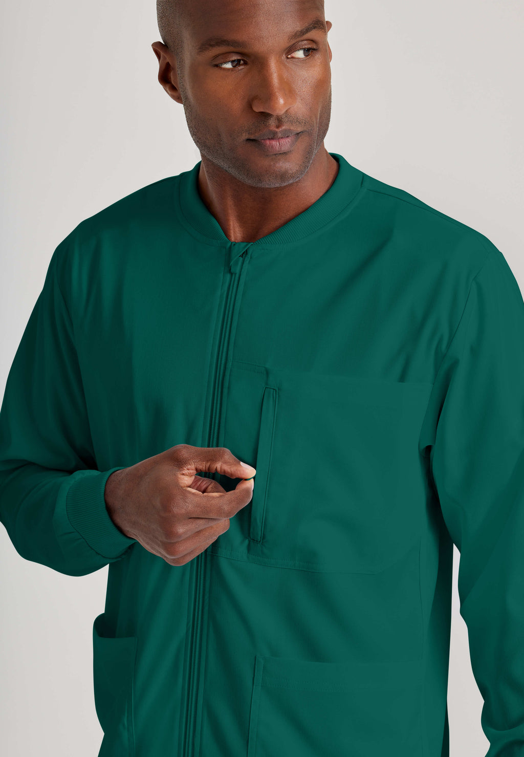 Detail Shot of the React 5-Pocket Crewneck Warmup Scrub Jacket in Hunter Green from Grey's Anatomy™ by Barco Spandex Stretch