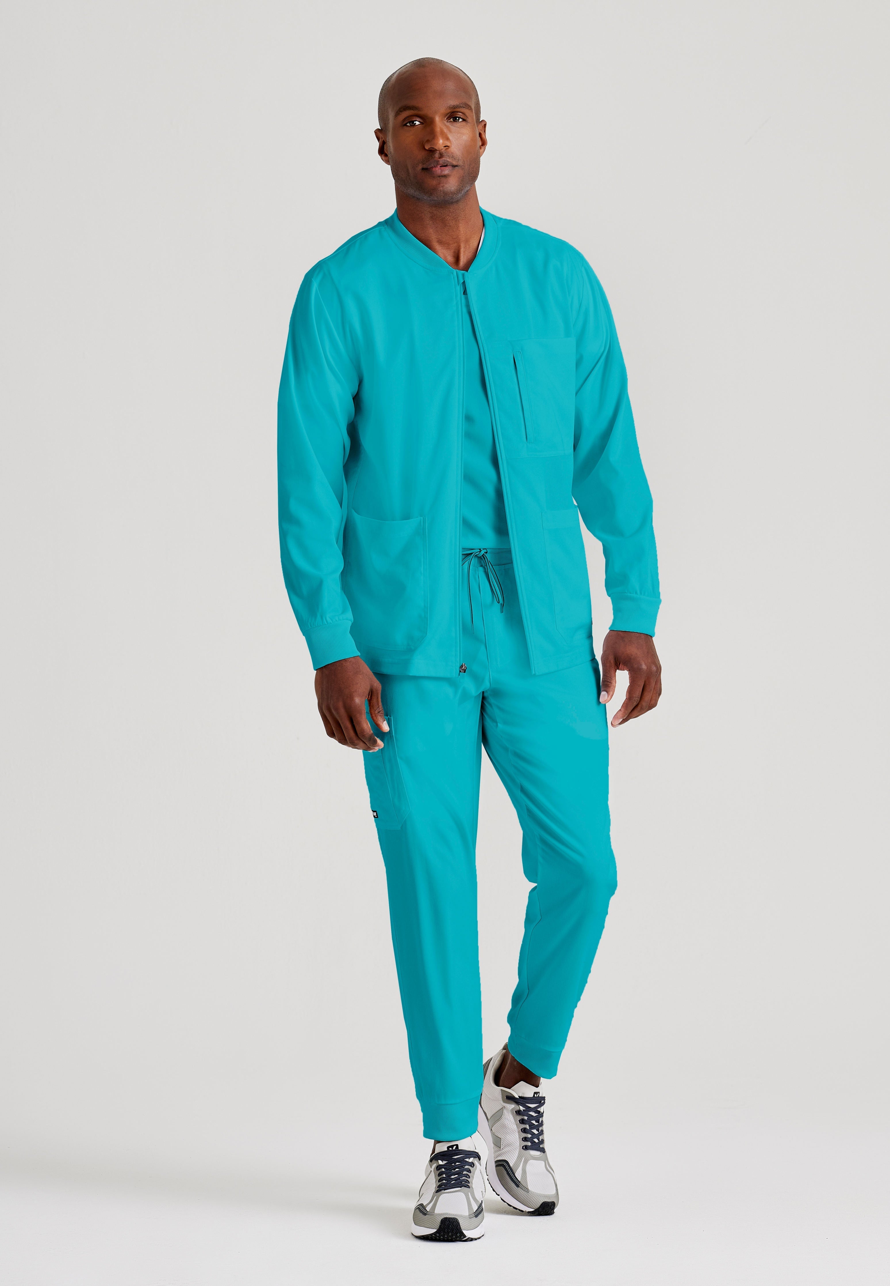 Grey's Anatomy Spandex-Stretch Men’s teal Warm-Up Scrub Jacket. Zip front with chin guard. Ribbed sleeve cuffs. 