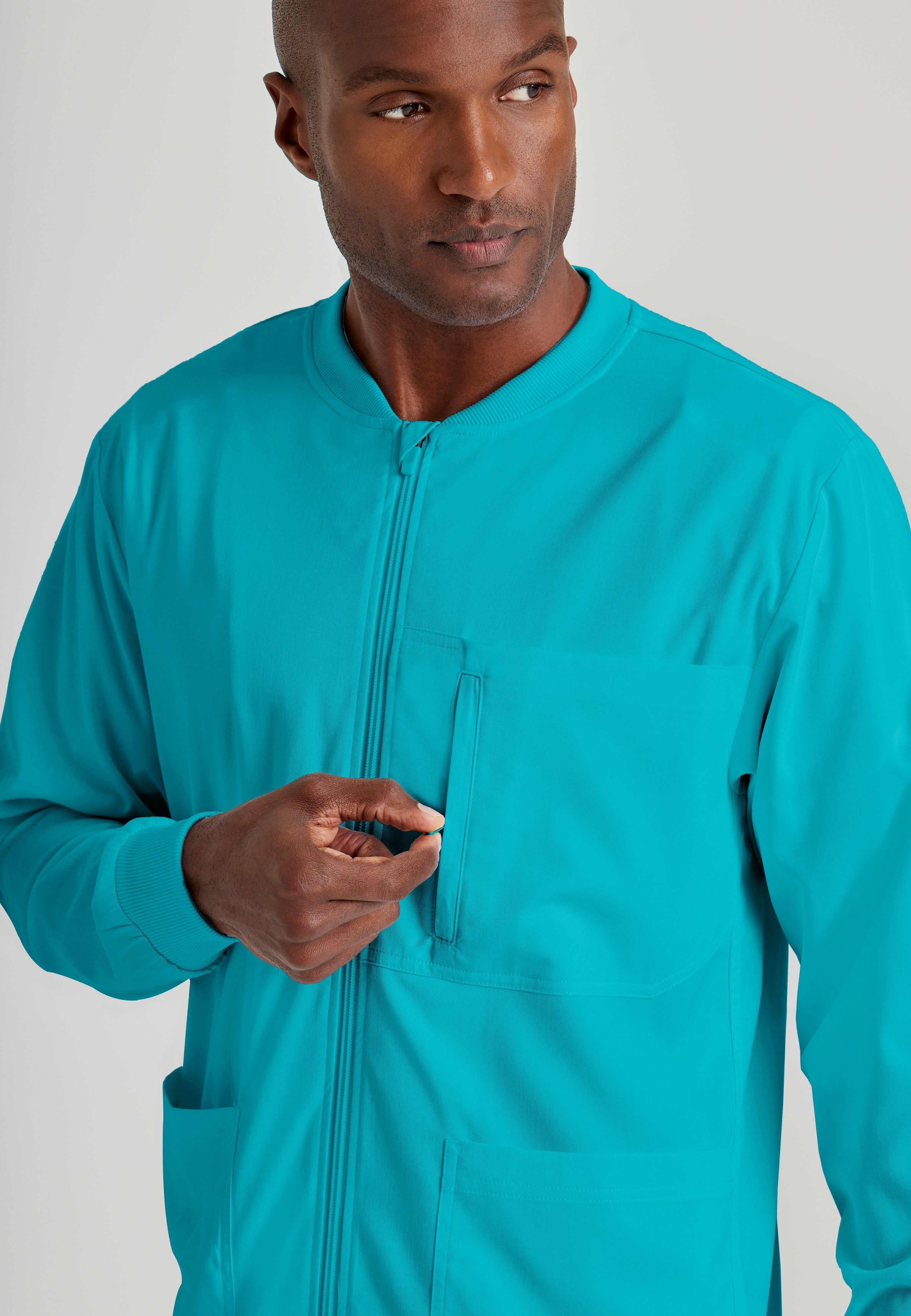 Grey's Anatomy Spandex-Stretch Men’s teal Warm-Up Scrub Jacket. Zip front with chin guard. Ribbed sleeve cuffs. 