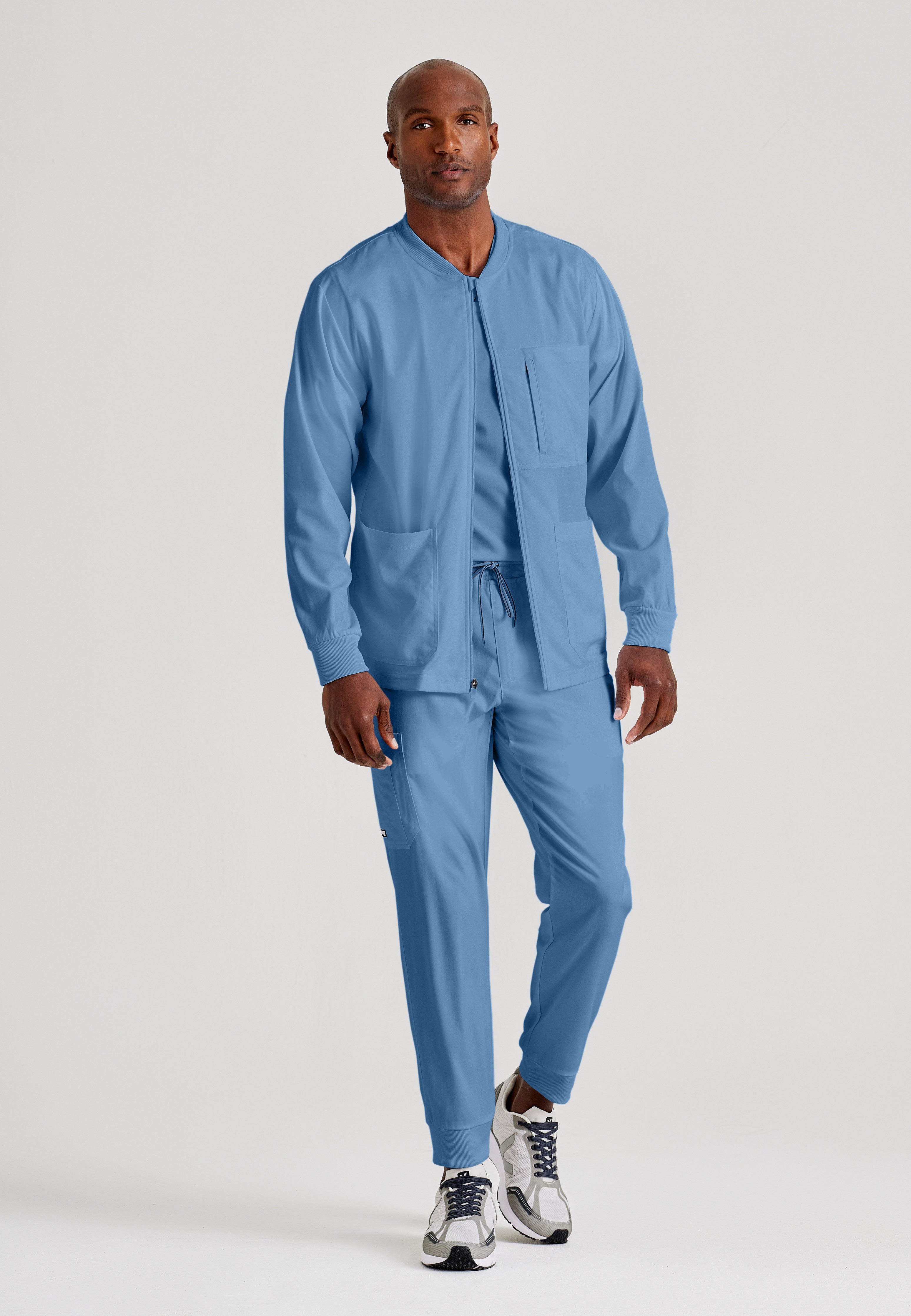 Full Body View of the React 5-Pocket Crewneck Warmup Scrub Jacket in Ciel Blue from Grey's Anatomy™ by Barco Spandex Stretch