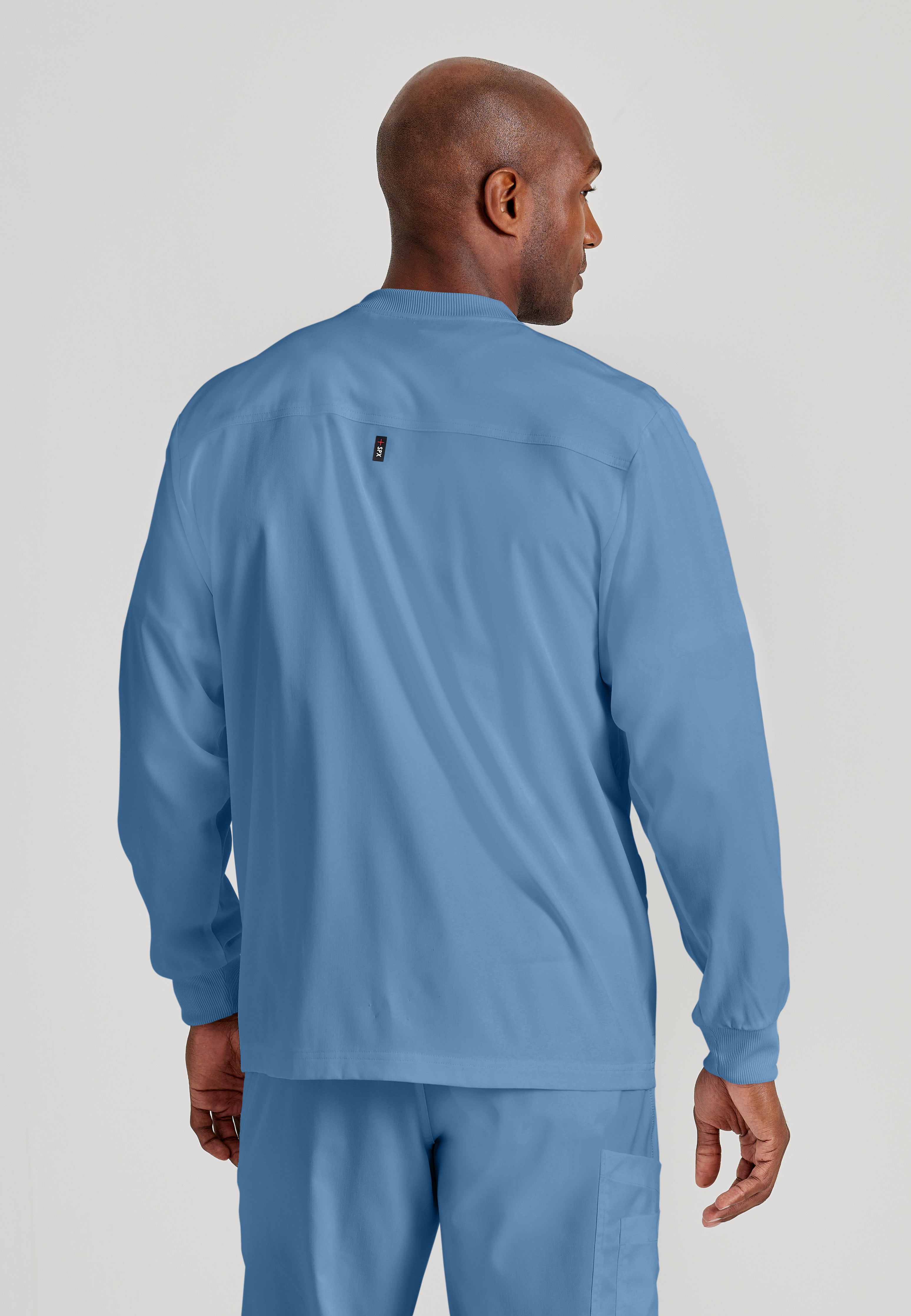 Back View of the React 5-Pocket Crewneck Warmup Scrub Jacket in Ciel Blue from Grey's Anatomy™ by Barco Spandex Stretch