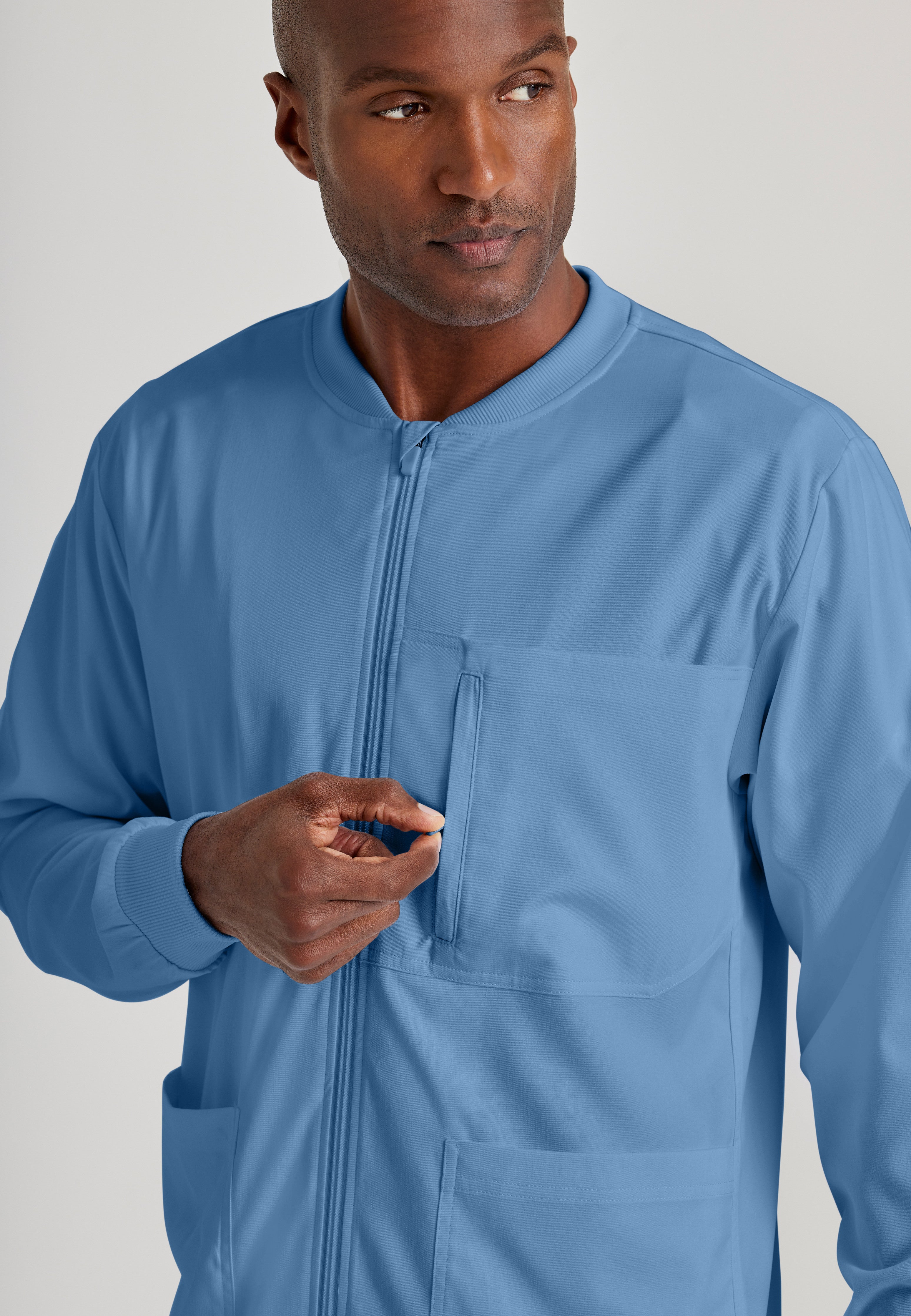 Detail Shot of the React 5-Pocket Crewneck Warmup Scrub Jacket in Ciel Blue from Grey's Anatomy™ by Barco Spandex Stretch