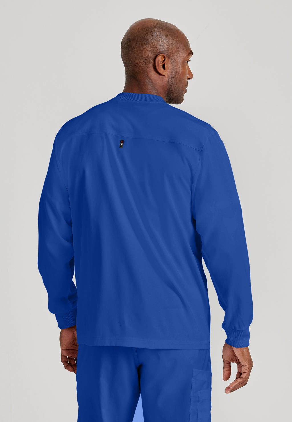 Back View of the React 5-Pocket Crewneck Warmup Scrub Jacket in Galaxy from Grey's Anatomy™ by Barco Spandex Stretch