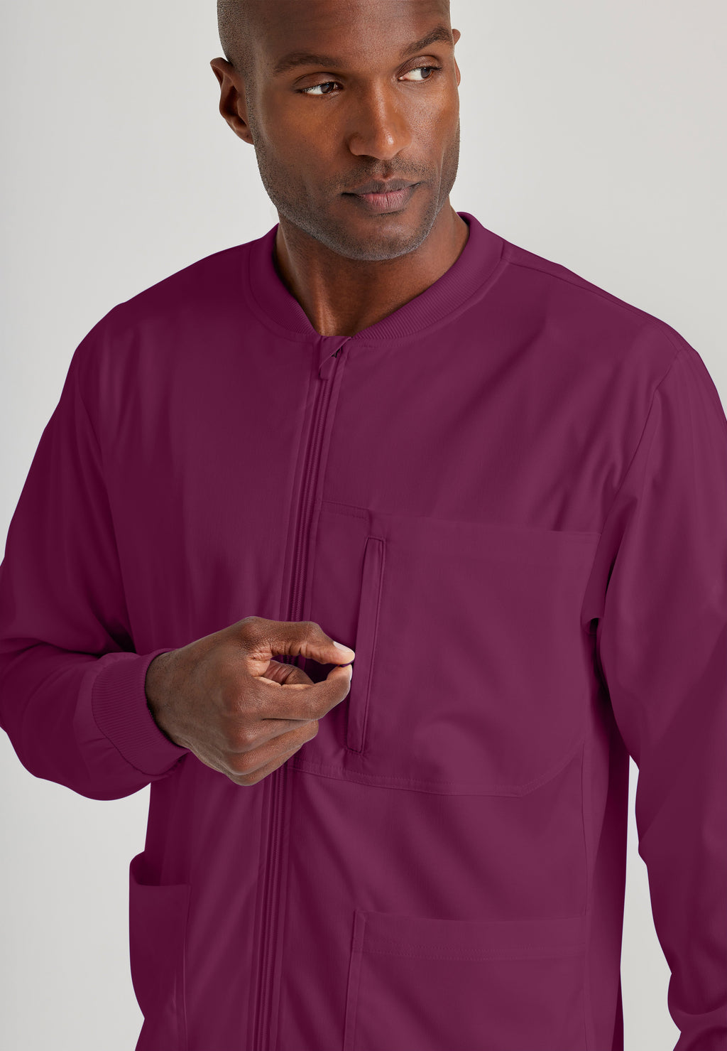 Detail Shot of the React 5-Pocket Crewneck Warmup Scrub Jacket in Wine from Grey's Anatomy™ by Barco Spandex Stretch