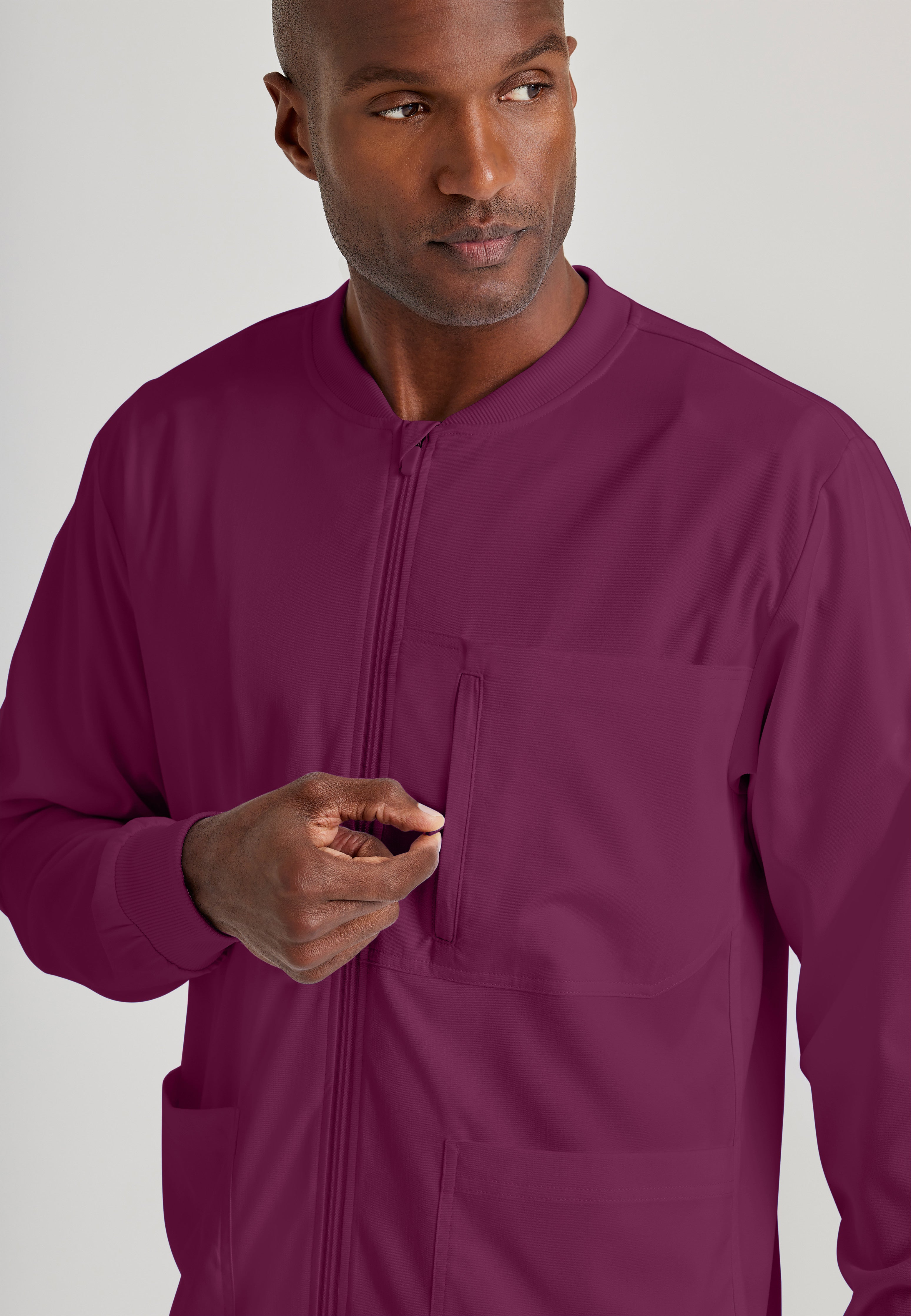 Detail Shot of the React 5-Pocket Crewneck Warmup Scrub Jacket in Wine from Grey's Anatomy™ by Barco Spandex Stretch