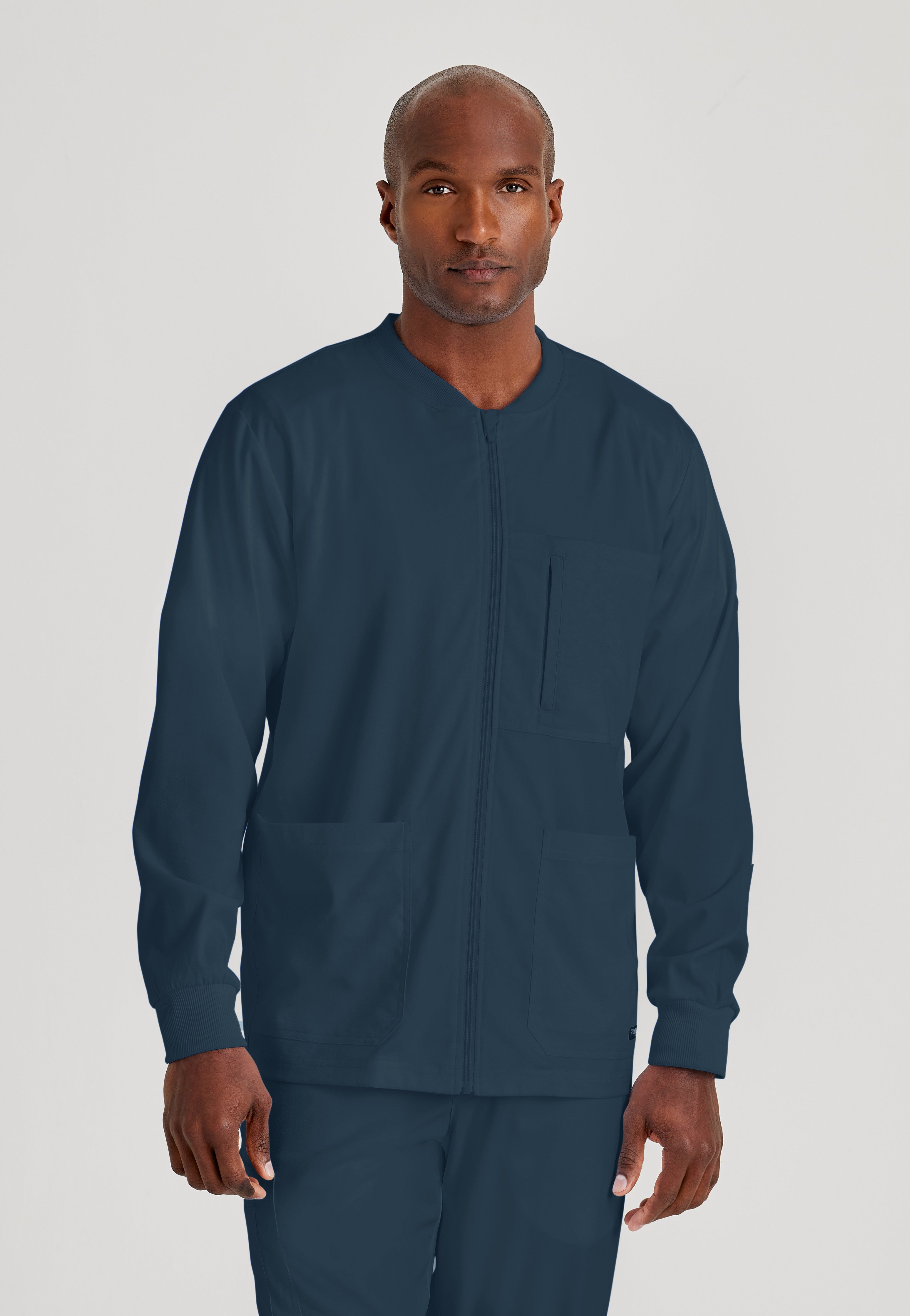 Front View of the React 5-Pocket Crewneck Warmup Scrub Jacket in Steel from Grey's Anatomy™ by Barco Spandex Stretch