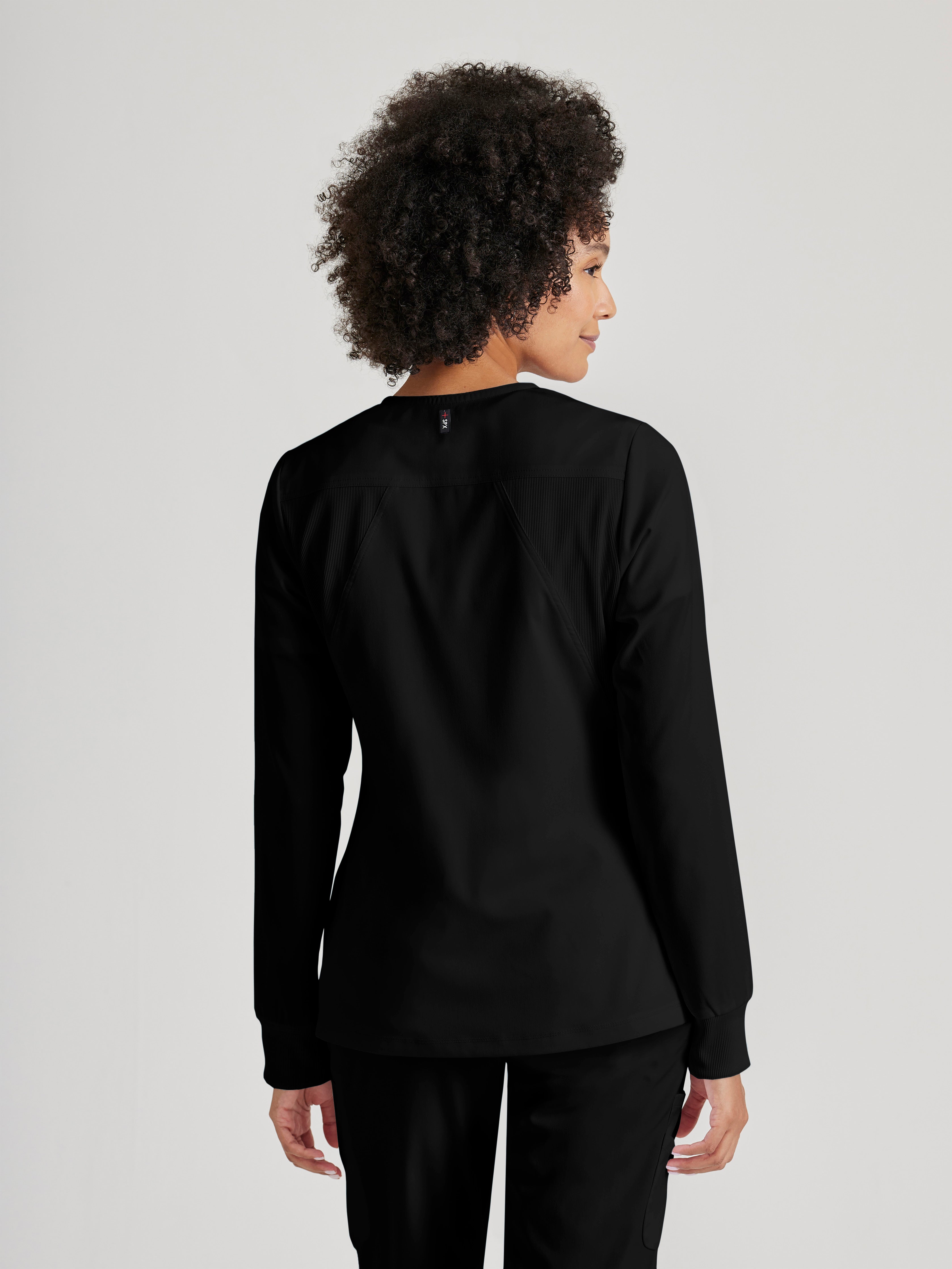 Side View of the Gianna 5-Pocket Crewneck Scrub Jacket in Black from Grey's Anatomy™ by Barco Spandex Stretch
