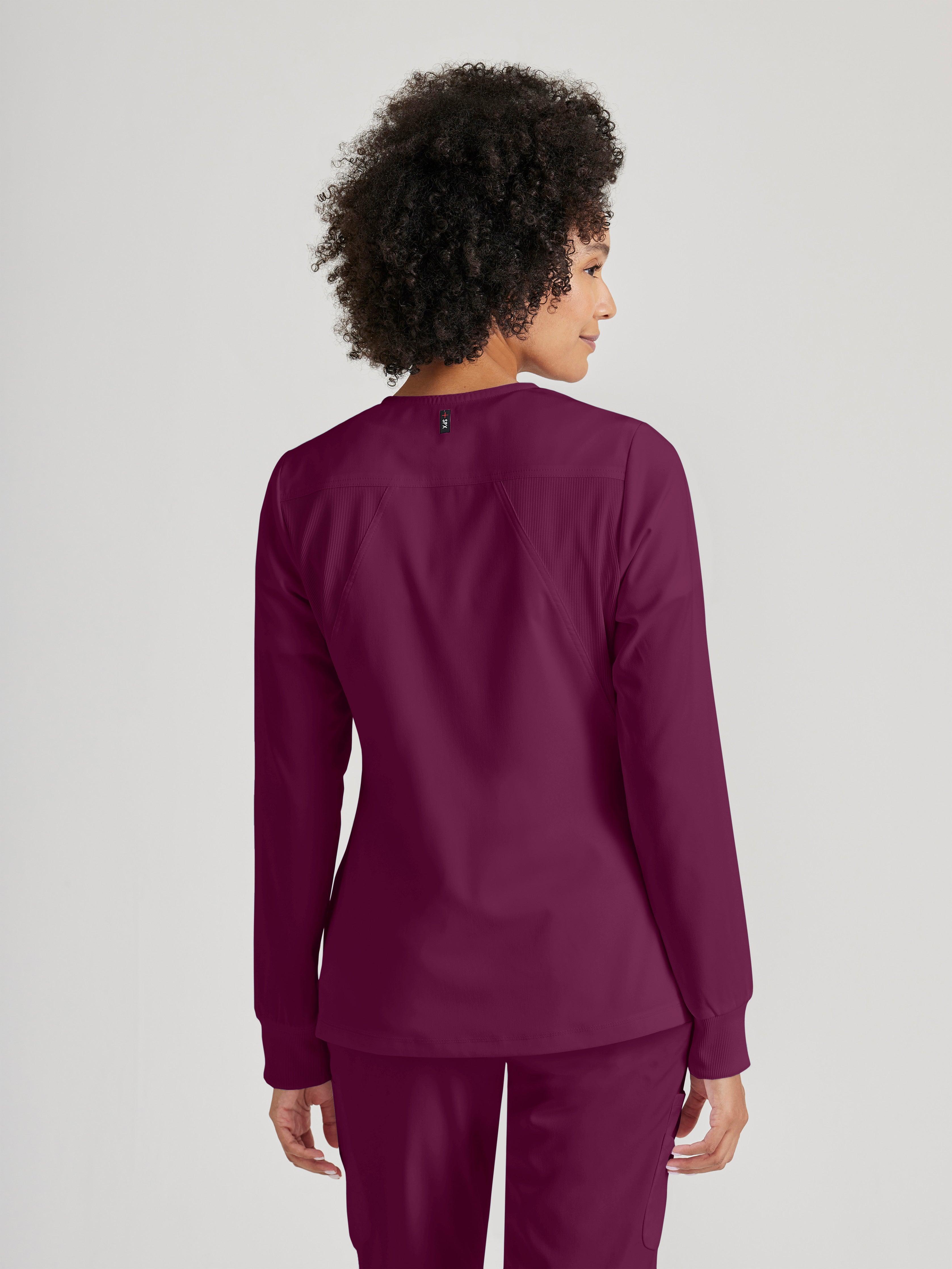 Side View of the Gianna 5-Pocket Crewneck Scrub Jacket in Wine from Grey's Anatomy™ by Barco Spandex Stretch