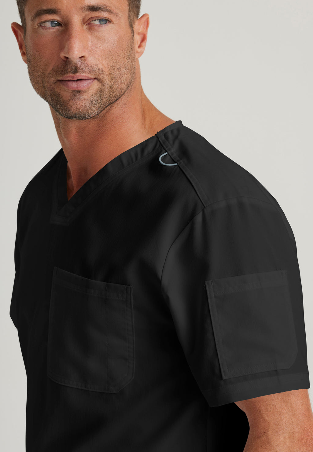 Detail Shot of the Evan 2-Pocket V-Neck Scrub Top in Black from Grey's Anatomy™ by Barco Classic