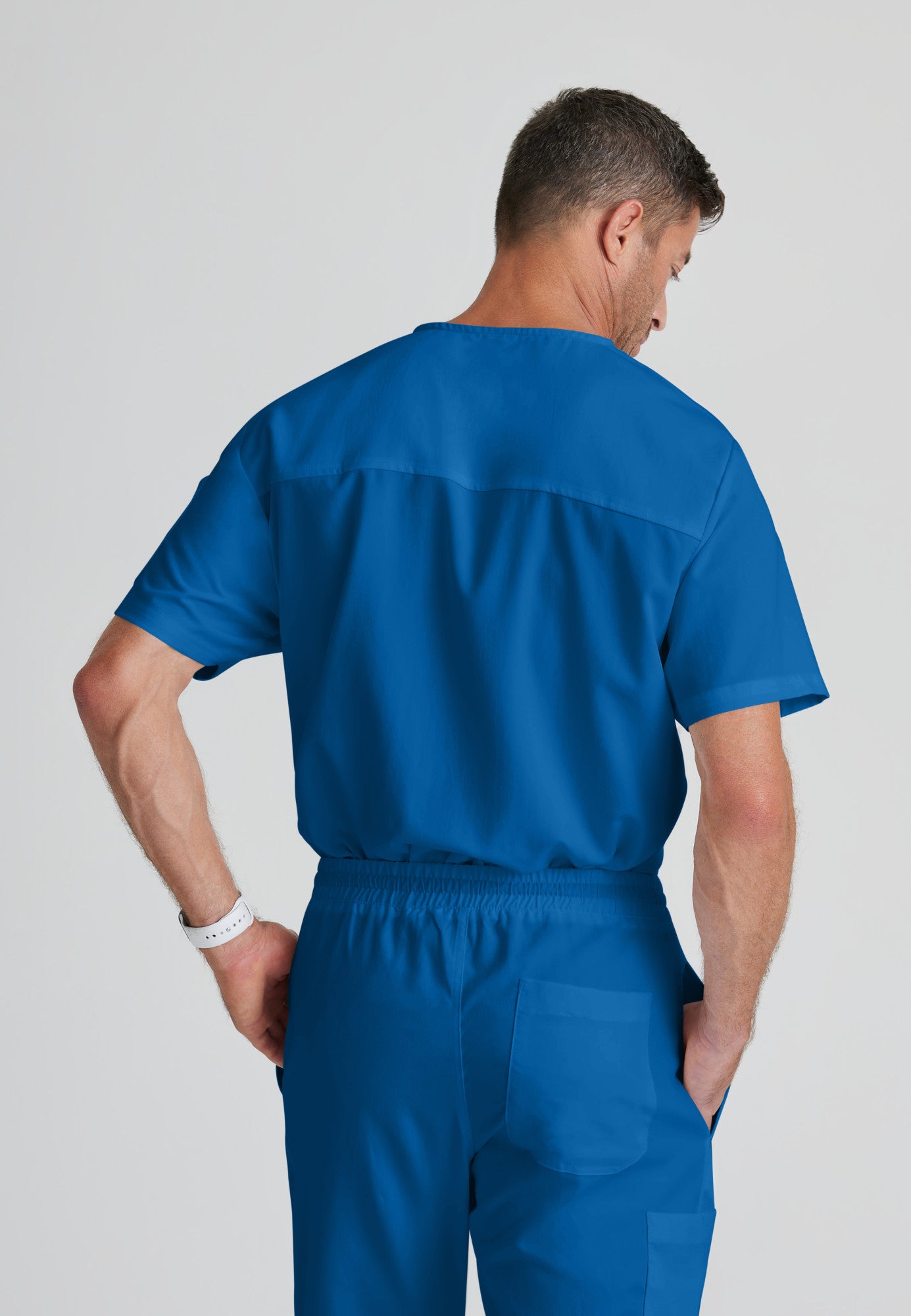 Back View of the Evan 2-Pocket V-Neck Scrub Top in New Royal from Grey's Anatomy™ by Barco Classic