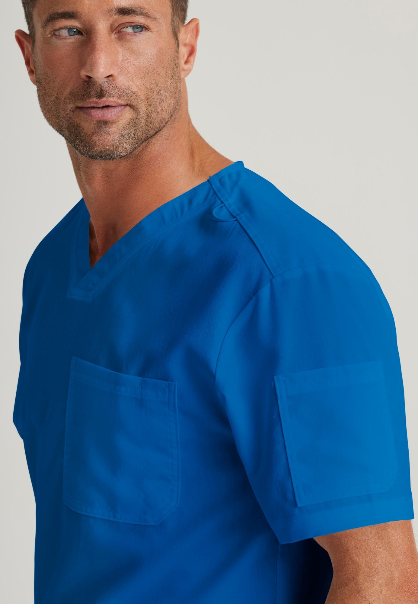 Detail Shot of the Evan 2-Pocket V-Neck Scrub Top in New Royal from Grey's Anatomy™ by Barco Classic