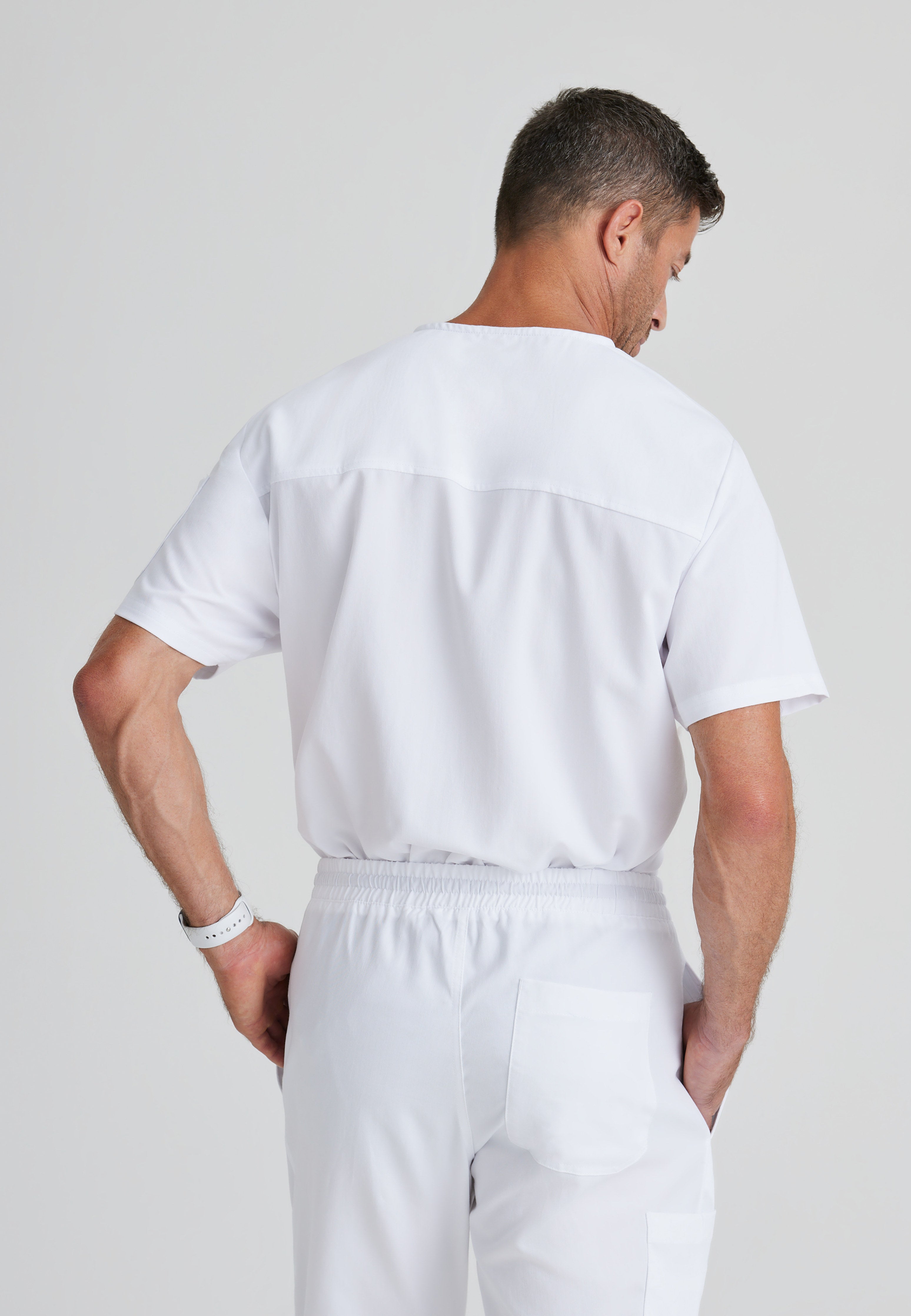 Back View of the Evan 2-Pocket V-Neck Scrub Top in White from Grey's Anatomy™ by Barco Classic