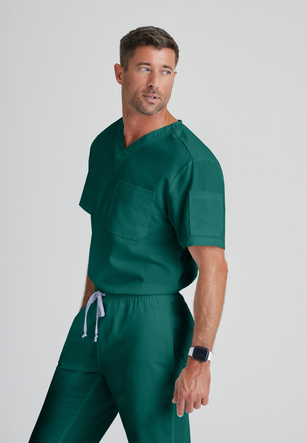 Side View of the Evan 2-Pocket V-Neck Scrub Top in Hunter Green from Grey's Anatomy™ by Barco Classic
