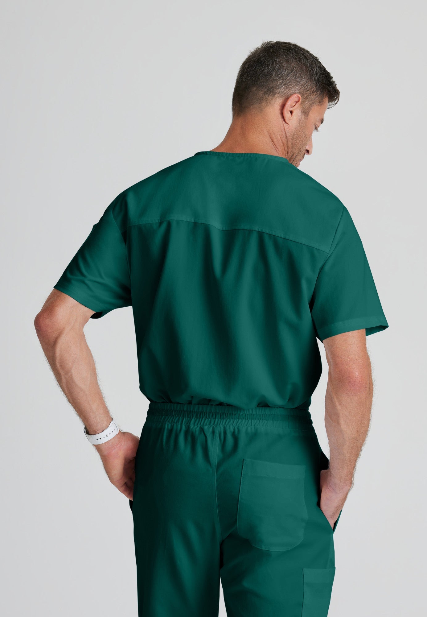 Back View of the Evan 2-Pocket V-Neck Scrub Top in Hunter Green from Grey's Anatomy™ by Barco Classic