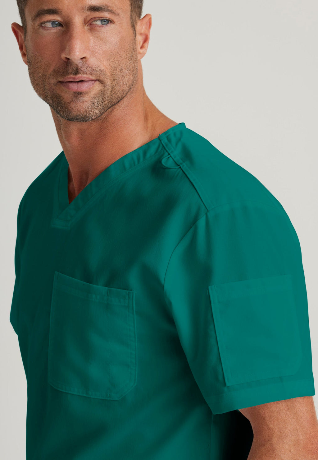 Detail Shot of the Evan 2-Pocket V-Neck Scrub Top in Hunter Green from Grey's Anatomy™ by Barco Classic