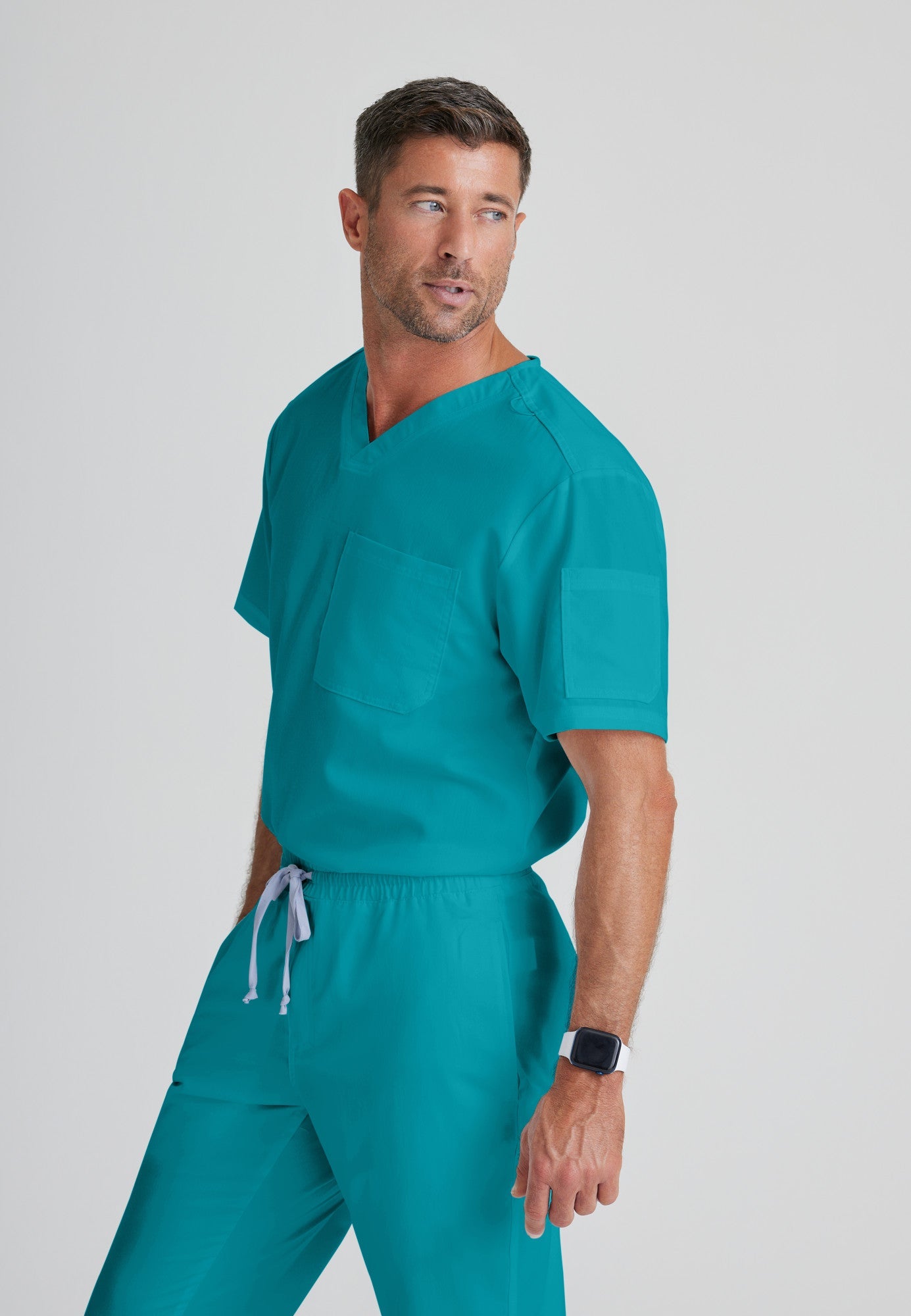 Side View of the Evan 2-Pocket V-Neck Scrub Top in Teal from Grey's Anatomy™ by Barco Classic