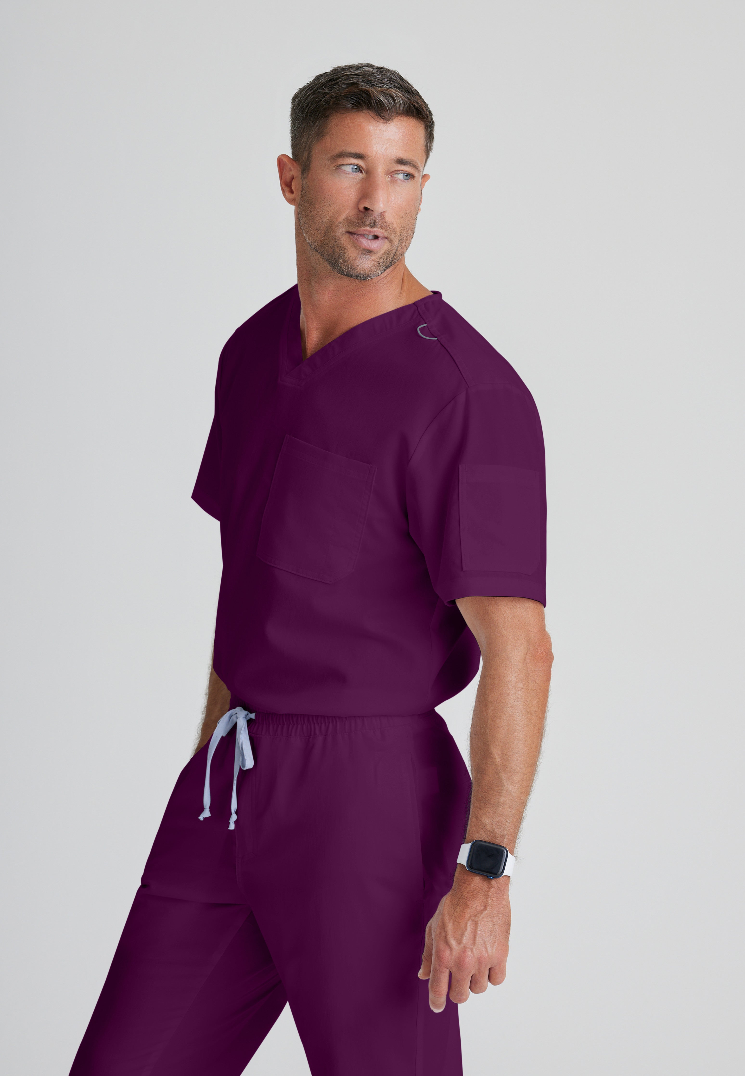 Side View of the Evan 2-Pocket V-Neck Scrub Top in Wine from Grey's Anatomy™ by Barco Classic