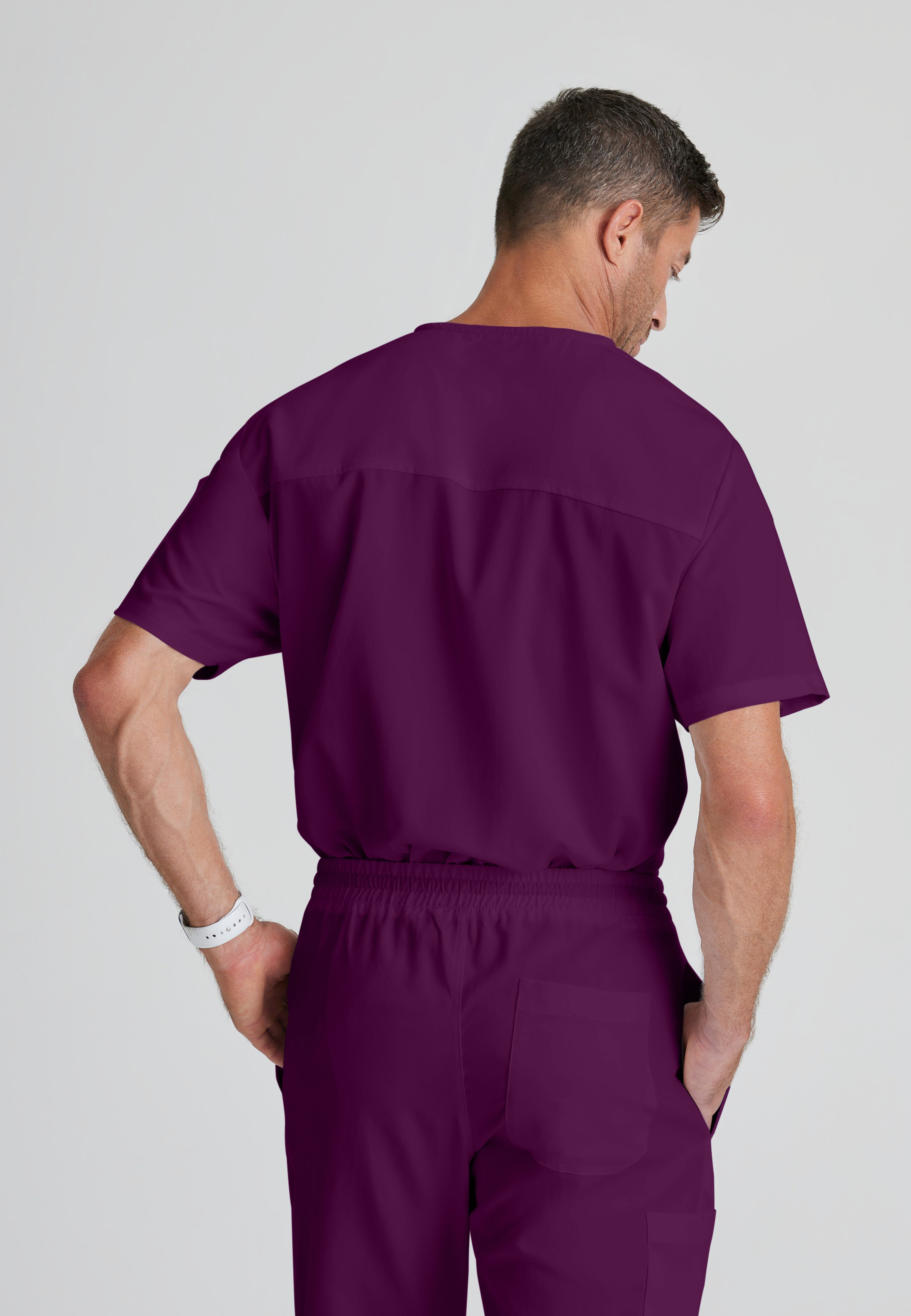 Back View of the Evan 2-Pocket V-Neck Scrub Top in Wine from Grey's Anatomy™ by Barco Classic