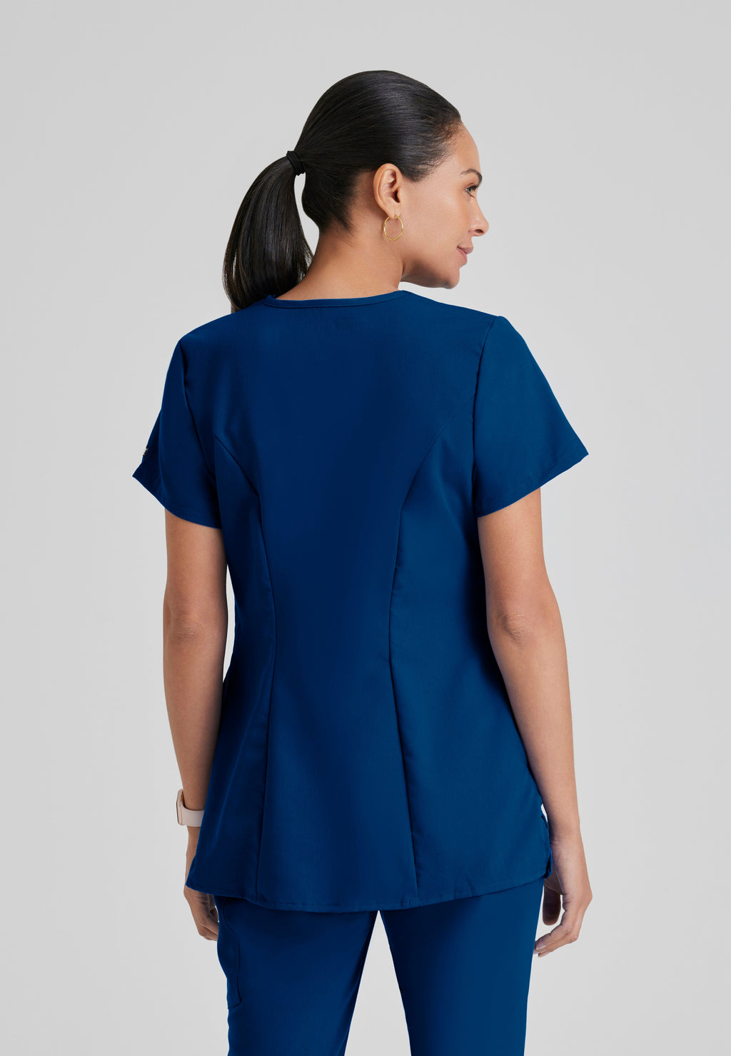 Back View of the Lilah 2-Pocket Mock Wrap Maternity Scrub Top in Indigo from Grey's Anatomy™ by Barco Classic