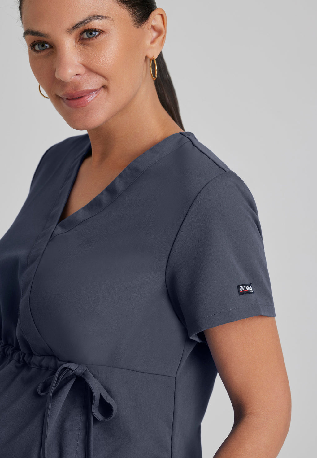 Detail Shot of the Lilah 2-Pocket Mock Wrap Maternity Scrub Top in Steel from Grey's Anatomy™ by Barco Classic