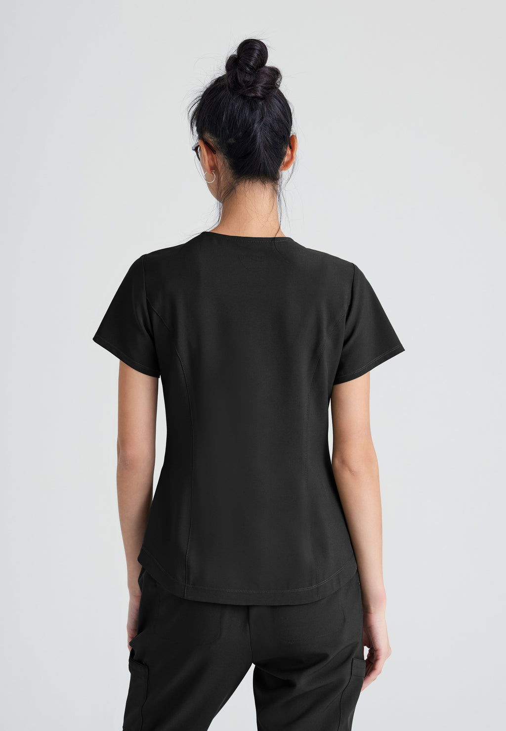 Back View of the Rhythm 2-Pocket Ciclo® Scrub Top in Black from Grey's Anatomy™ by Barco Evolve