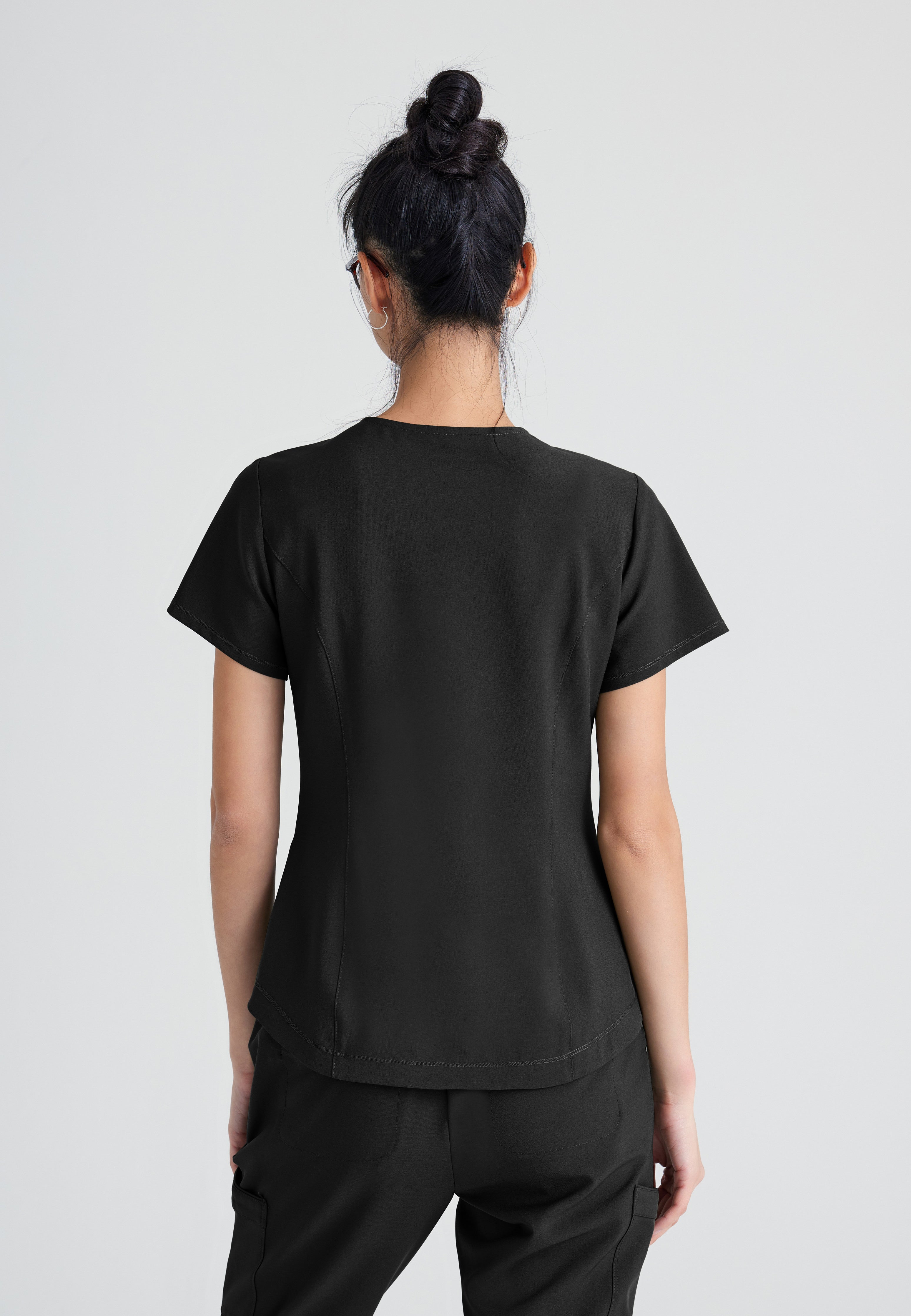 Back View of the Rhythm 2-Pocket Ciclo® Scrub Top in Black from Grey's Anatomy™ by Barco Evolve
