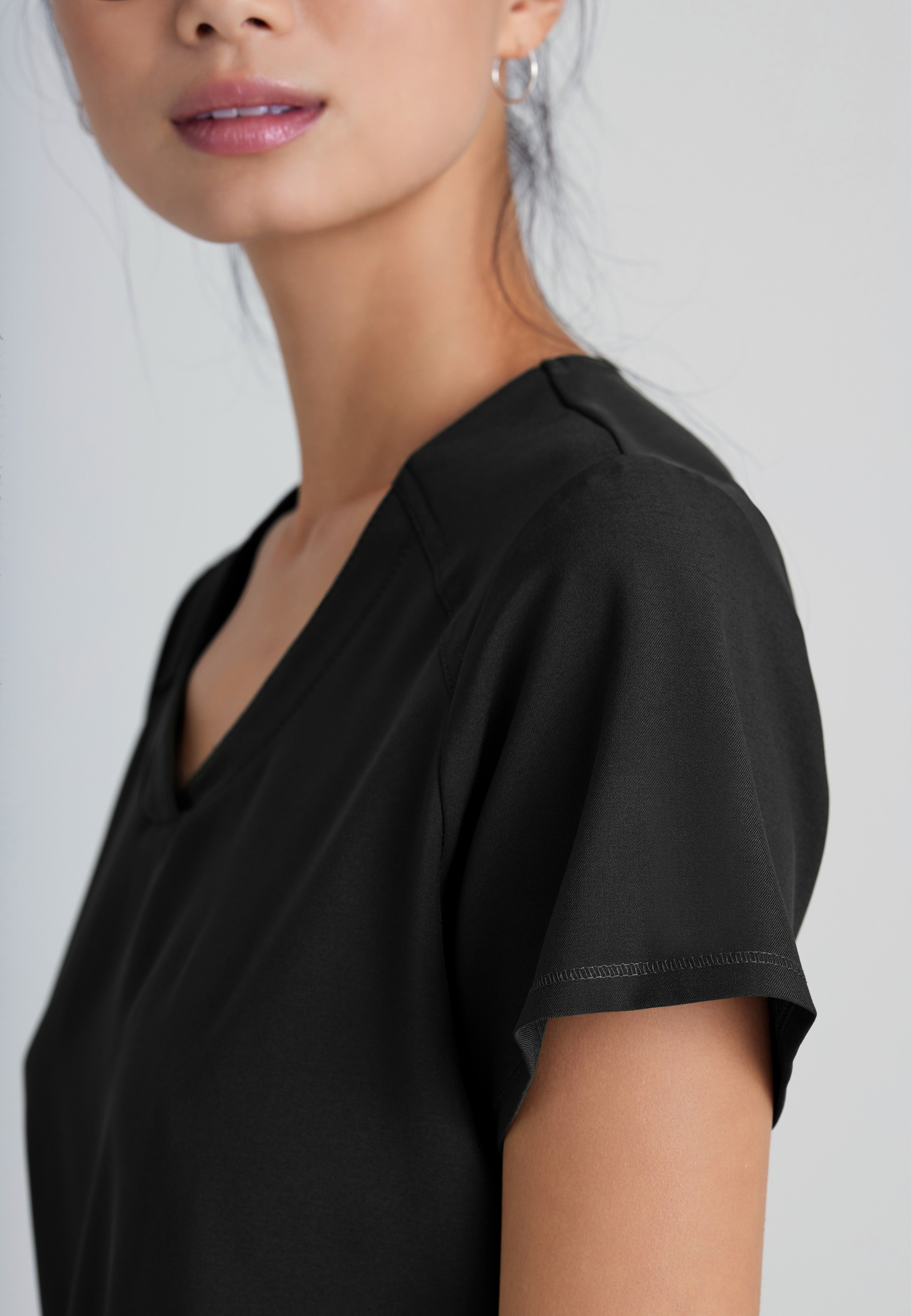 Detail Shot of the Rhythm 2-Pocket Ciclo® Scrub Top in Black from Grey's Anatomy™ by Barco Evolve