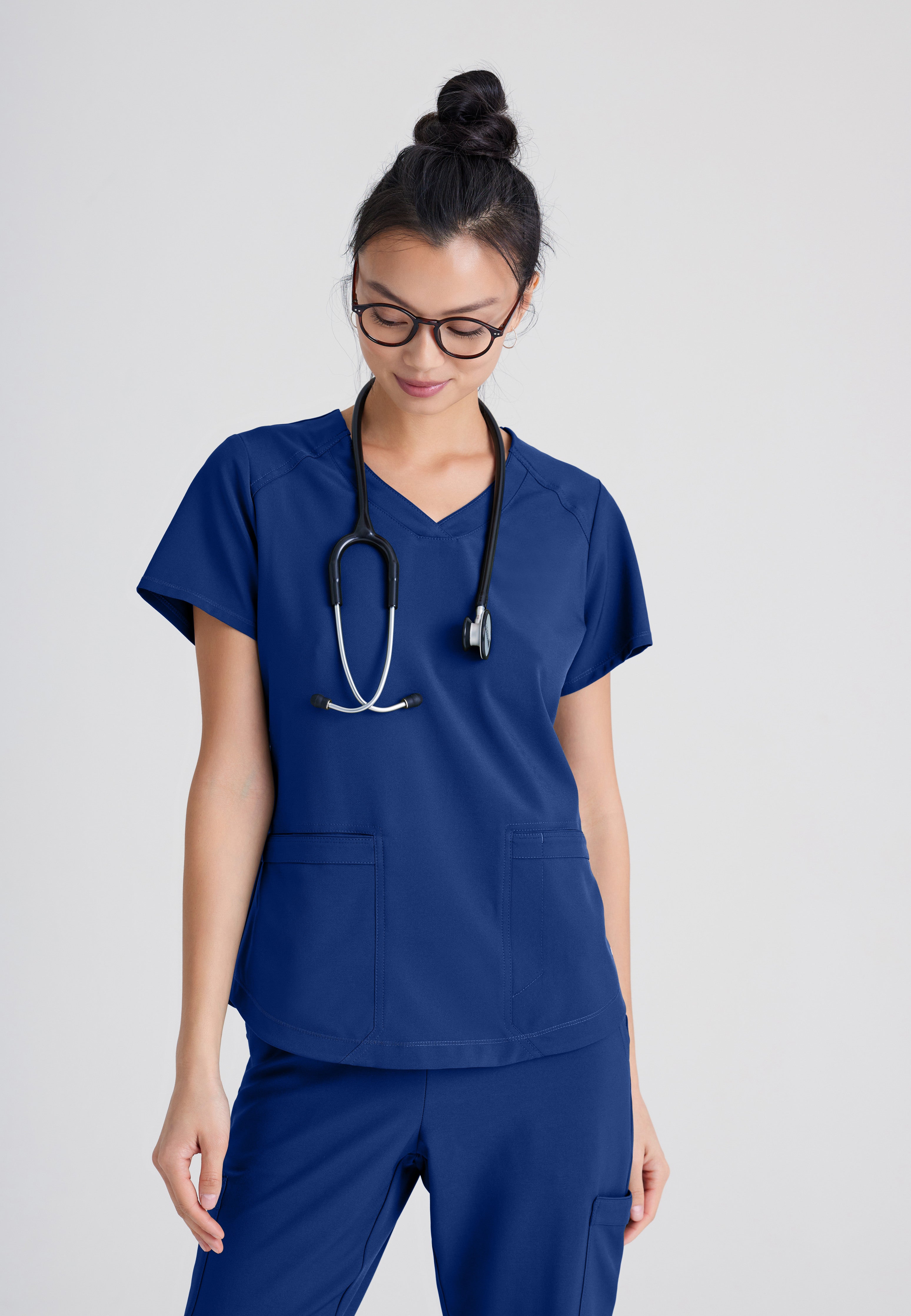 Front View of the Rhythm 2-Pocket Ciclo® Scrub Top in Indigo from Grey's Anatomy™ by Barco Evolve