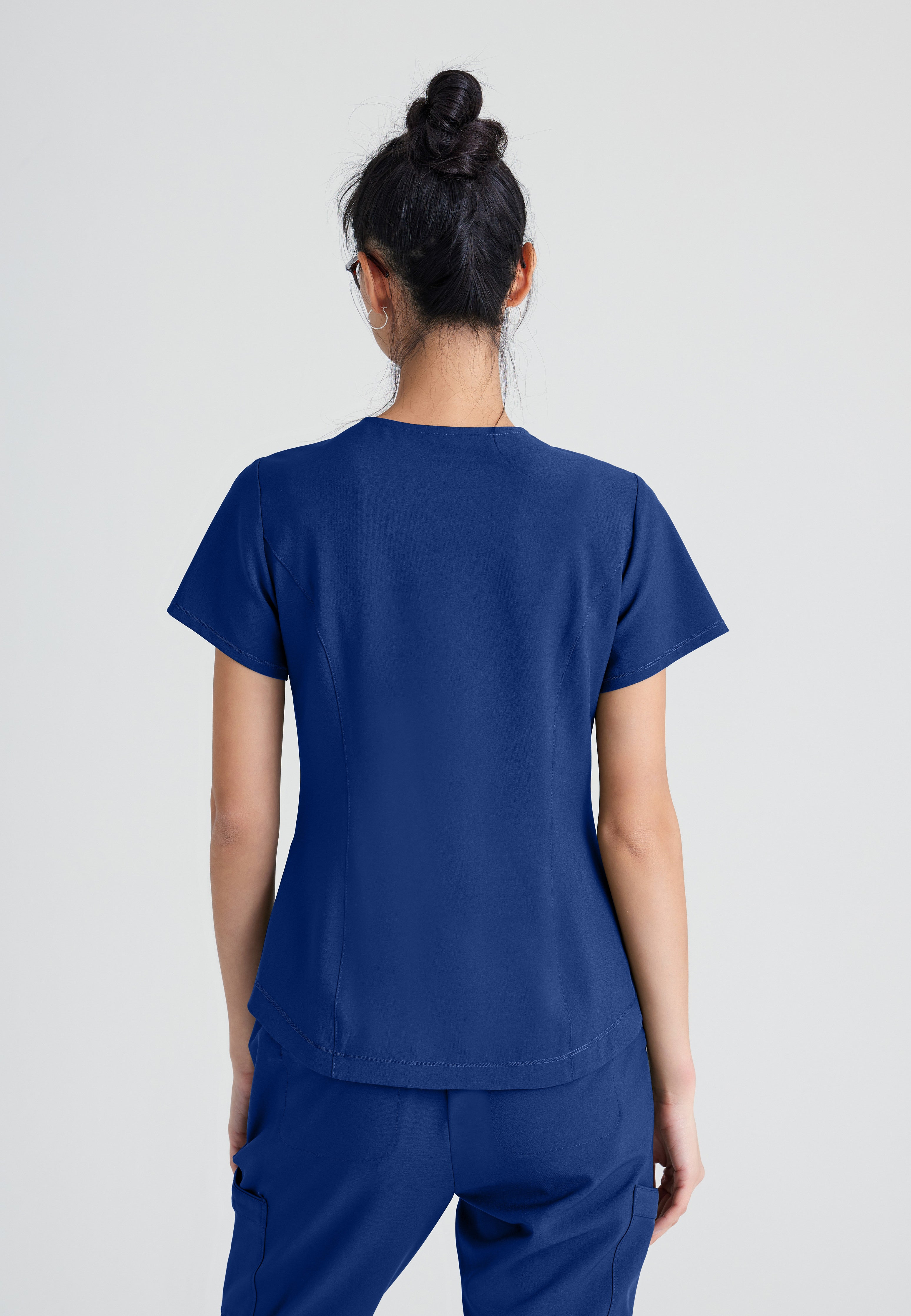 Back View of the Rhythm 2-Pocket Ciclo® Scrub Top in Indigo from Grey's Anatomy™ by Barco Evolve