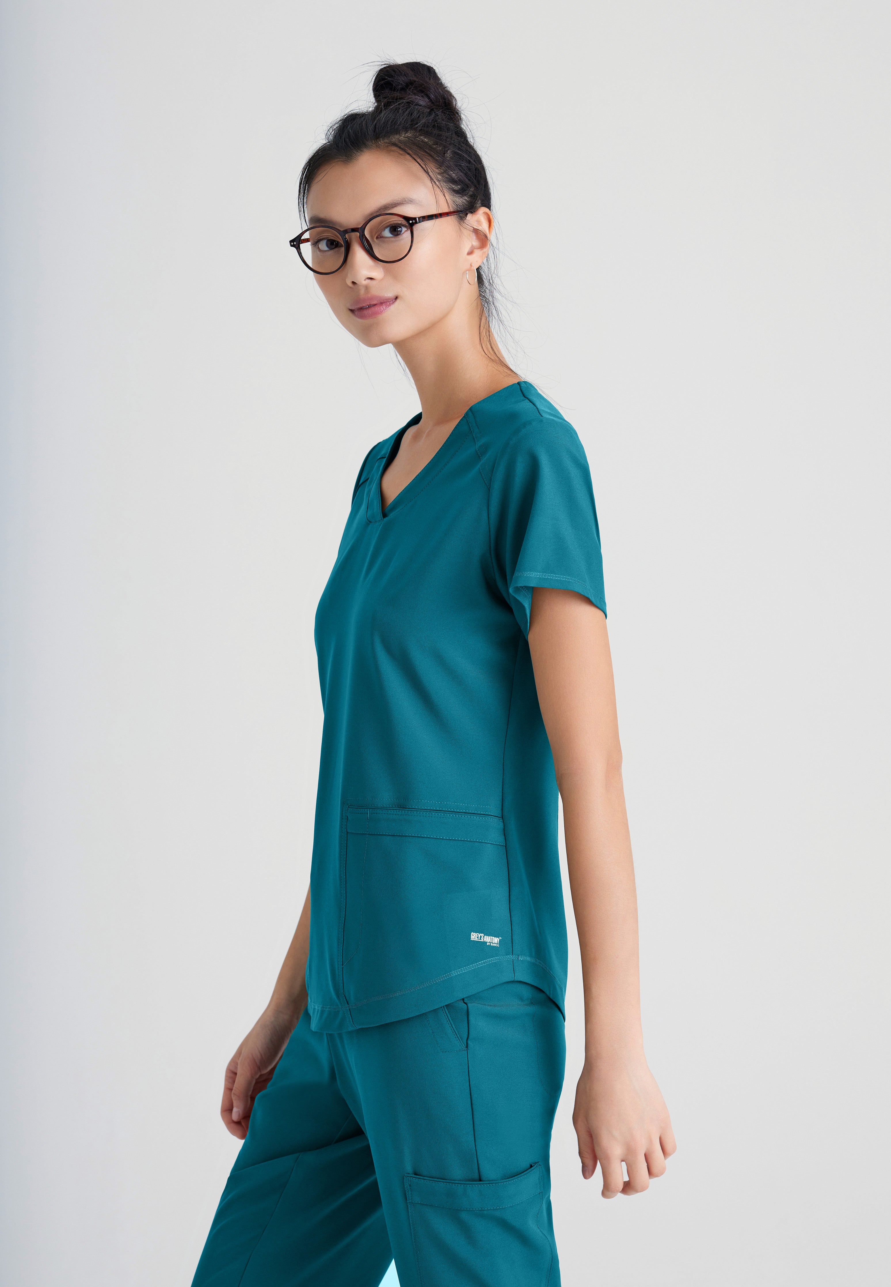 Side View of the Rhythm 2-Pocket Ciclo® Scrub Top in Bahama from Grey's Anatomy™ by Barco Evolve
