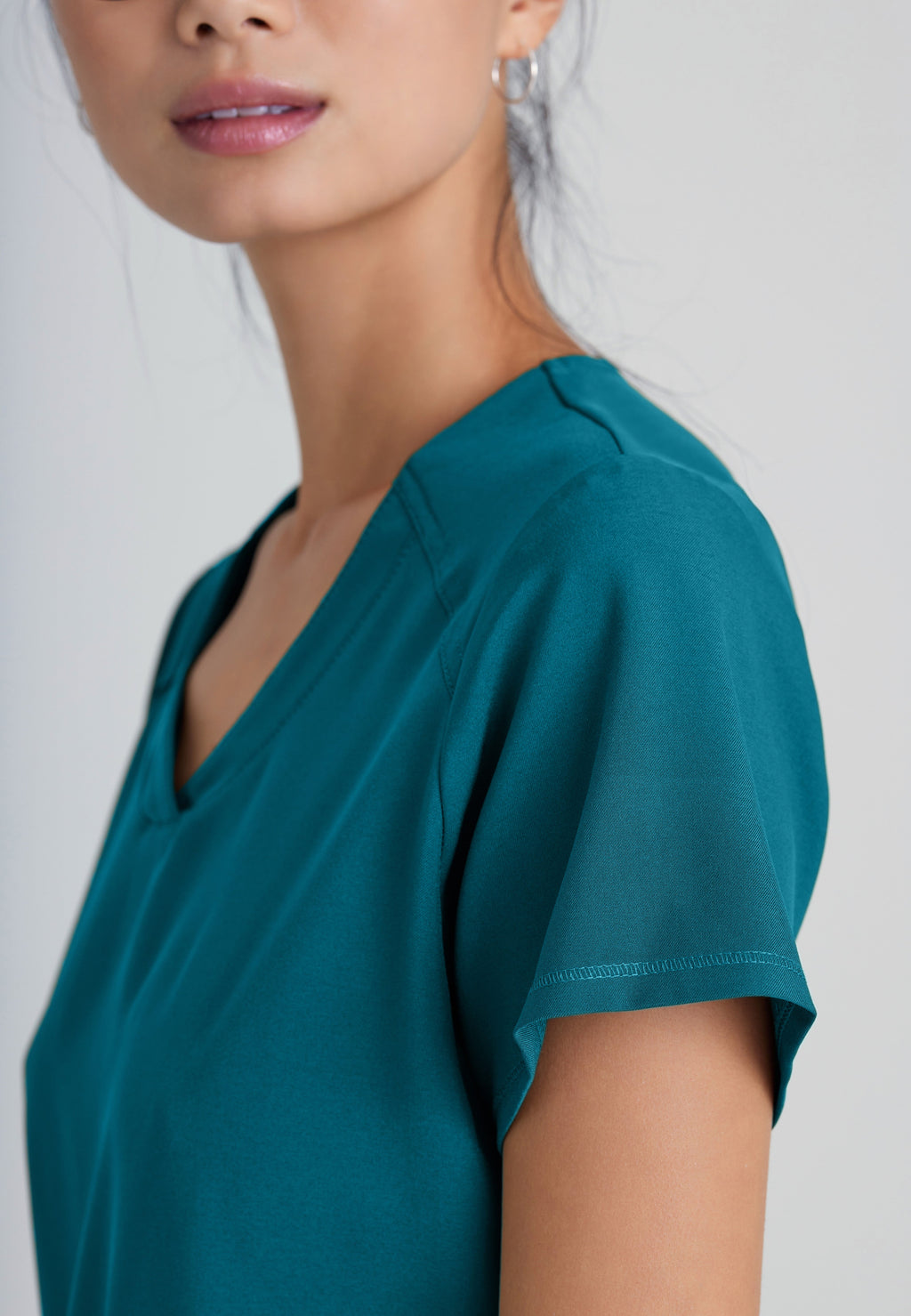 Detail Shot of the Rhythm 2-Pocket Ciclo® Scrub Top in Bahama from Grey's Anatomy™ by Barco Evolve