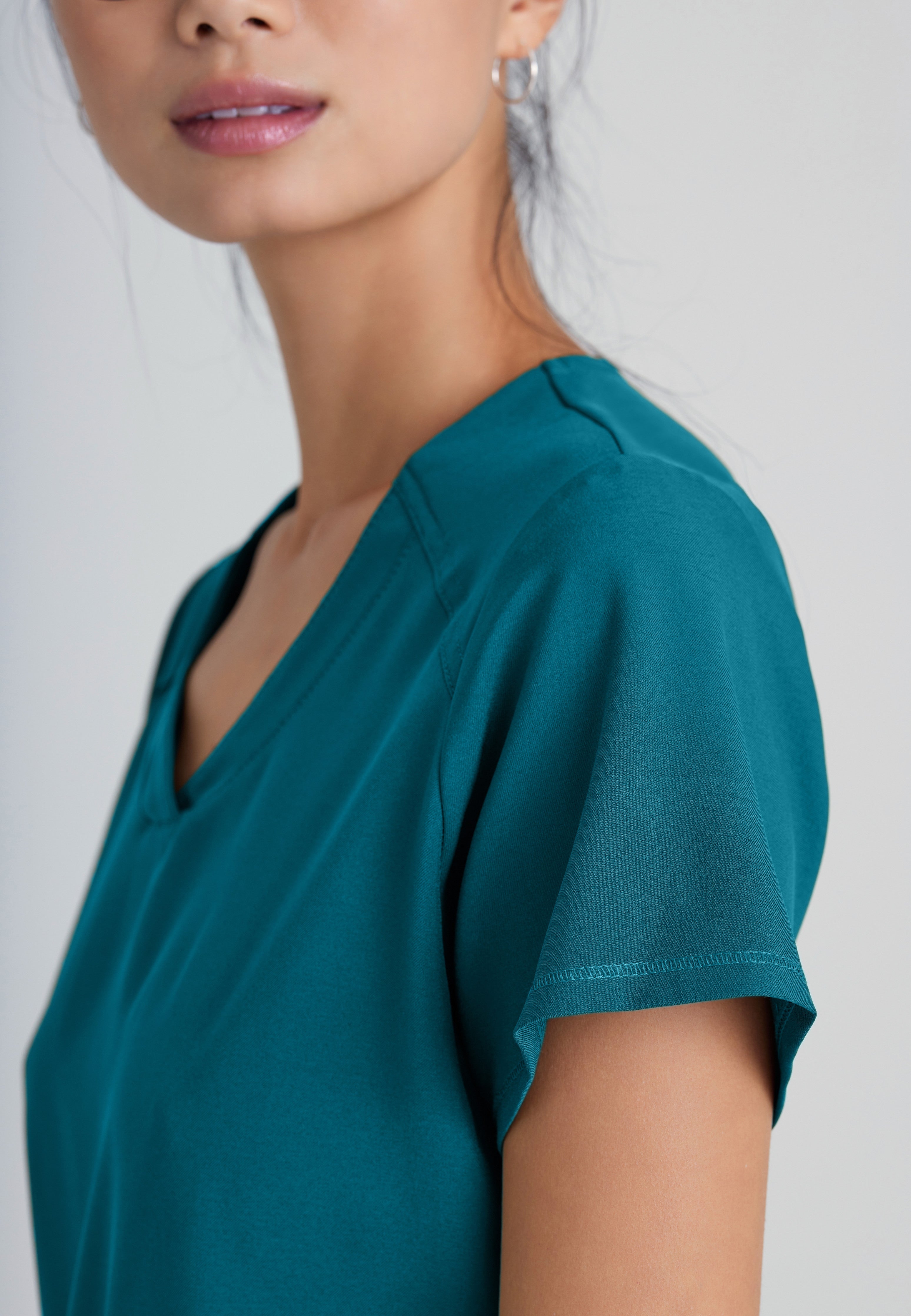 Detail Shot of the Rhythm 2-Pocket Ciclo® Scrub Top in Bahama from Grey's Anatomy™ by Barco Evolve