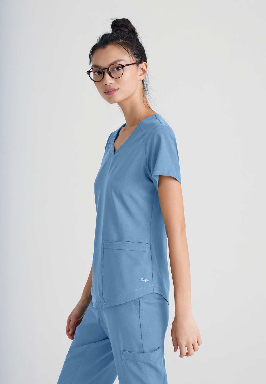 Side View of the Rhythm 2-Pocket Ciclo® Scrub Top in Ciel Blue from Grey's Anatomy™ by Barco Evolve