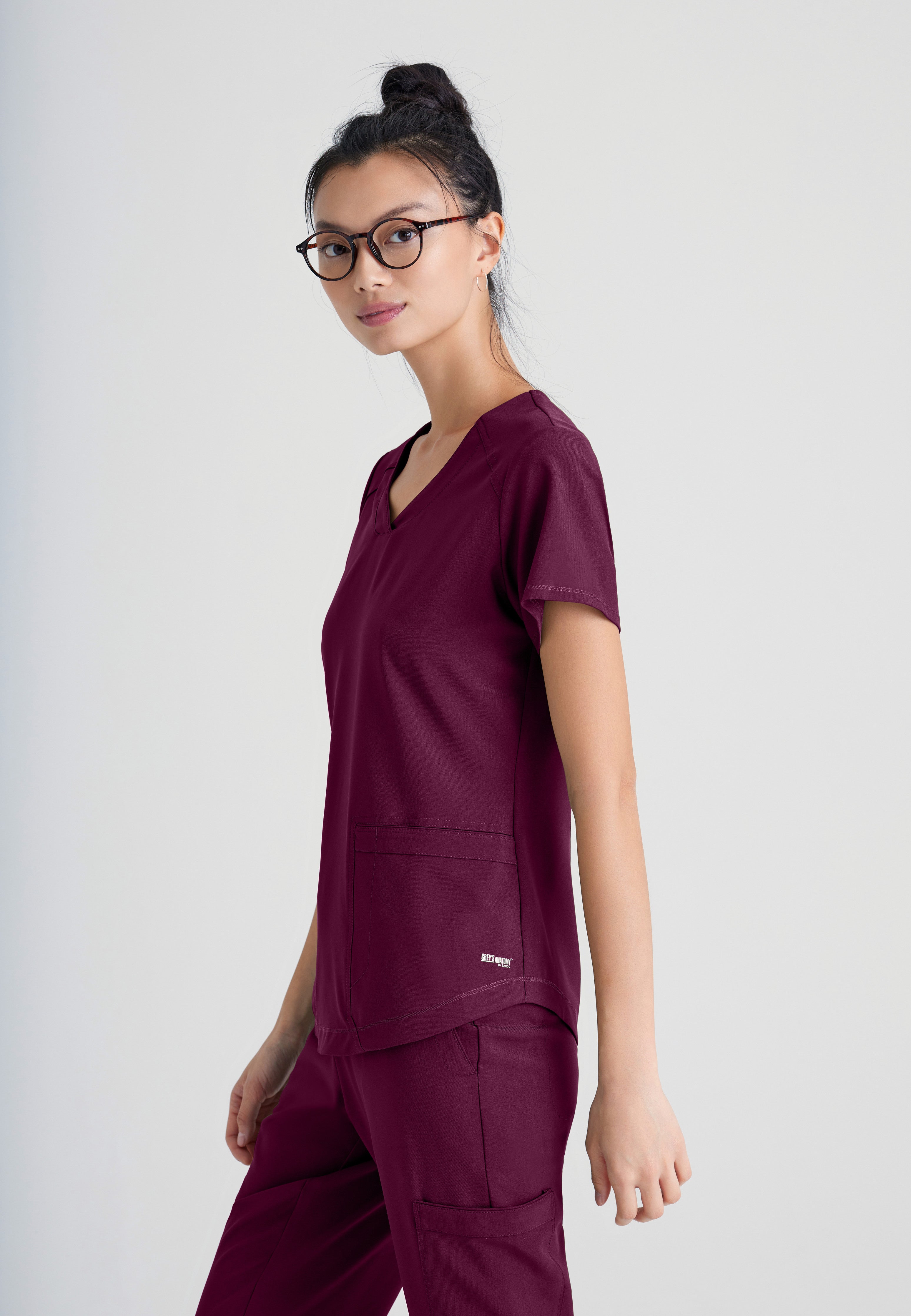 Side View of the Rhythm 2-Pocket Ciclo® Scrub Top in Wine from Grey's Anatomy™ by Barco Evolve