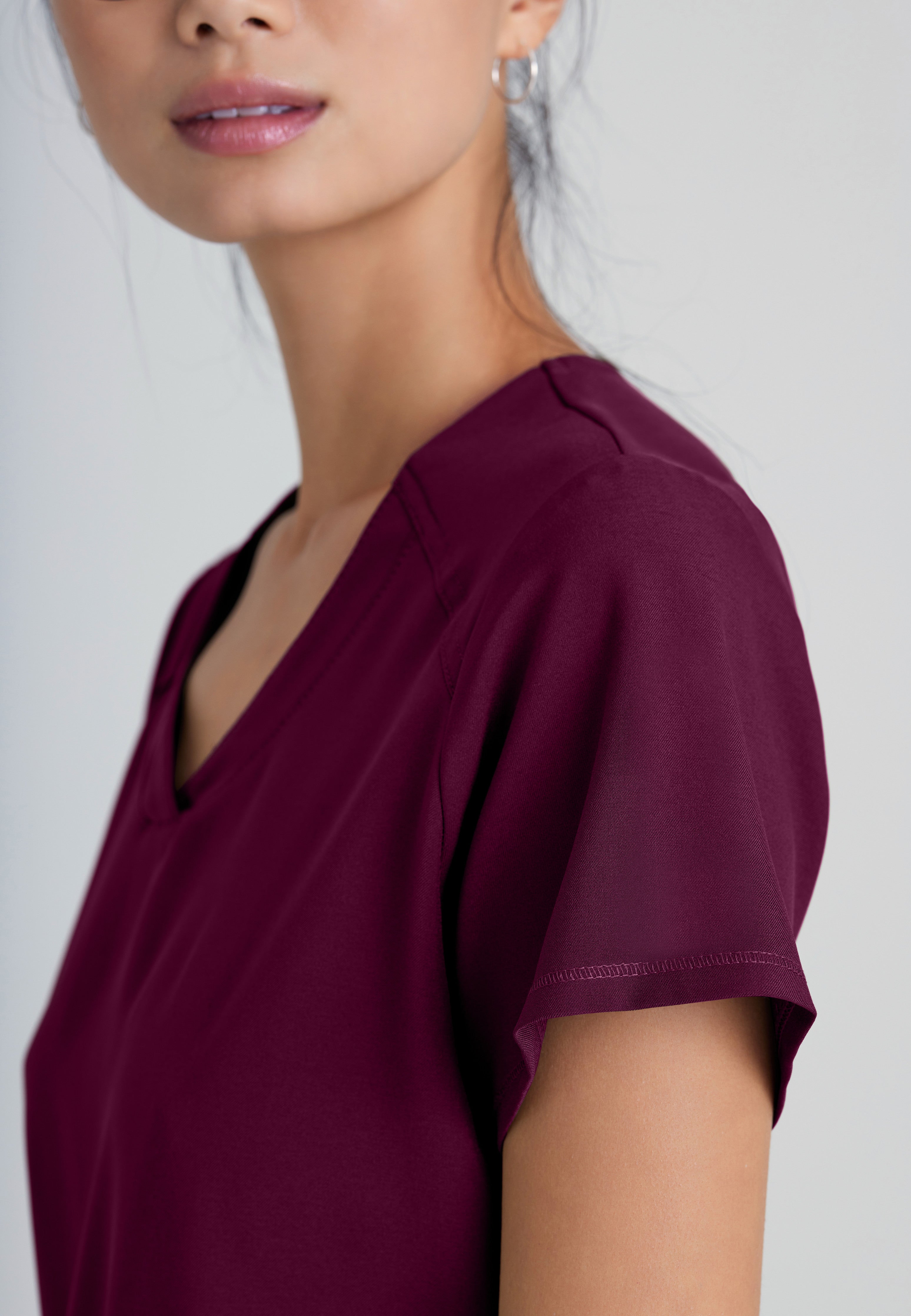 Detail Shot of the Rhythm 2-Pocket Ciclo® Scrub Top in Wine from Grey's Anatomy™ by Barco Evolve