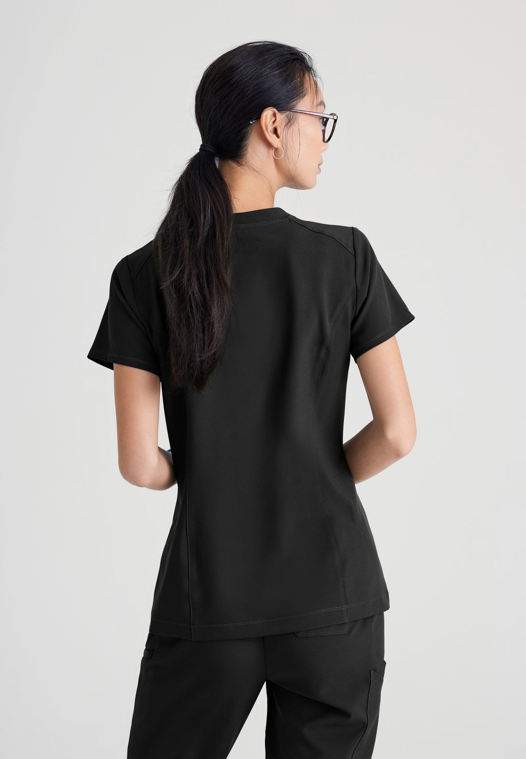 Back View of the Sway 1-Pocket Banded V-Neck Ciclo® Scrub Top in Black from Grey's Anatomy™ by Barco Evolve
