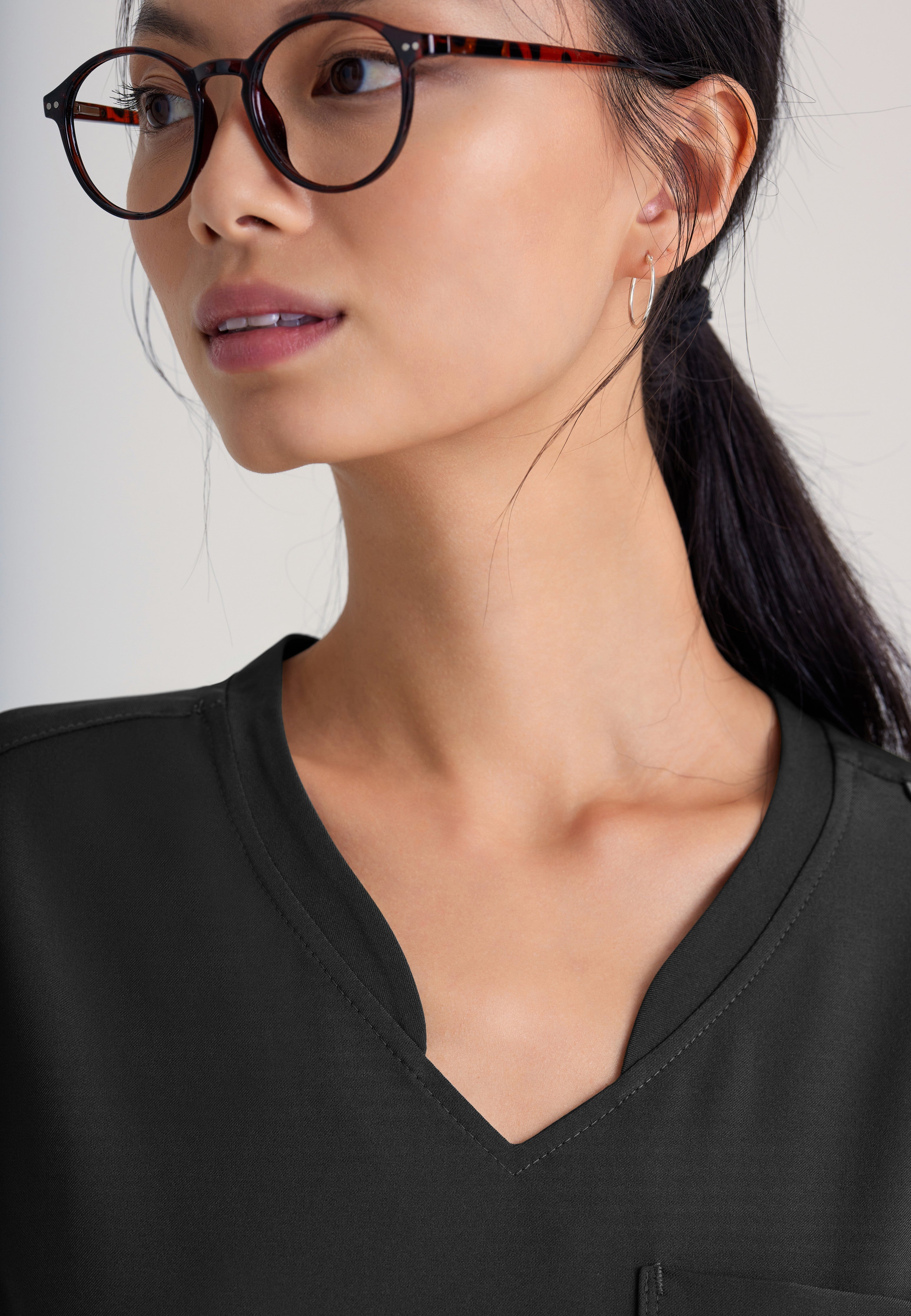 Detail Shot of the Sway 1-Pocket Banded V-Neck Ciclo® Scrub Top in Black from Grey's Anatomy™ by Barco Evolve