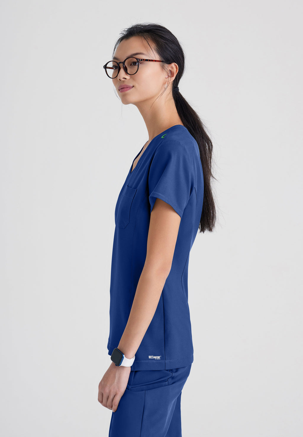 Side View of the Sway 1-Pocket Banded V-Neck Ciclo® Scrub Top in Indigo from Grey's Anatomy™ by Barco Evolve