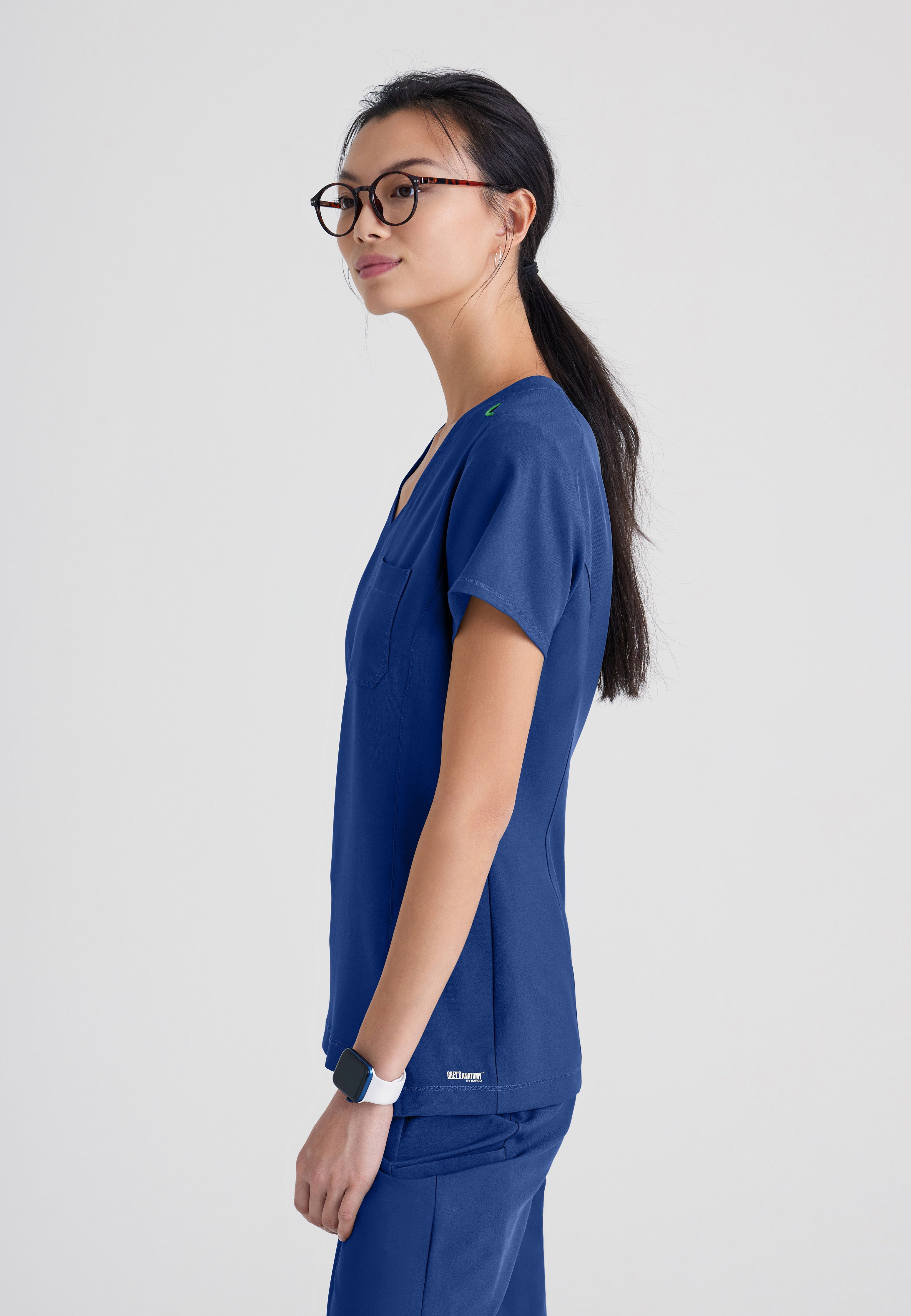 Side View of the Sway 1-Pocket Banded V-Neck Ciclo® Scrub Top in Indigo from Grey's Anatomy™ by Barco Evolve