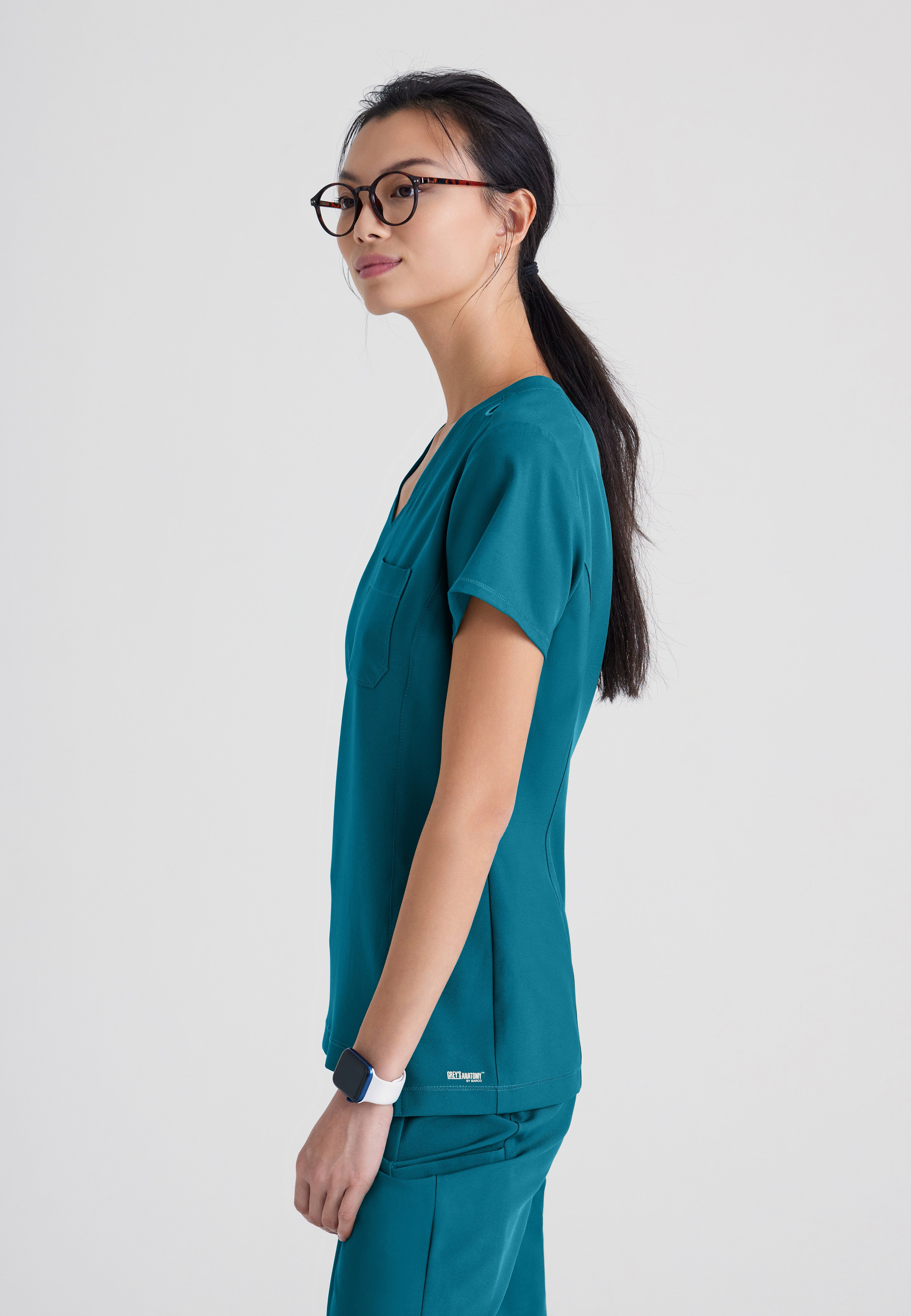 Side View of the Sway 1-Pocket Banded V-Neck Ciclo® Scrub Top in Bahama from Grey's Anatomy™ by Barco Evolve