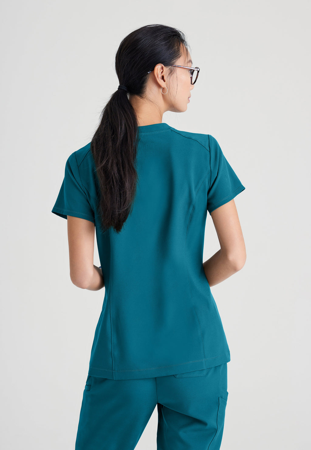 Back View of the Sway 1-Pocket Banded V-Neck Ciclo® Scrub Top in Bahama from Grey's Anatomy™ by Barco Evolve