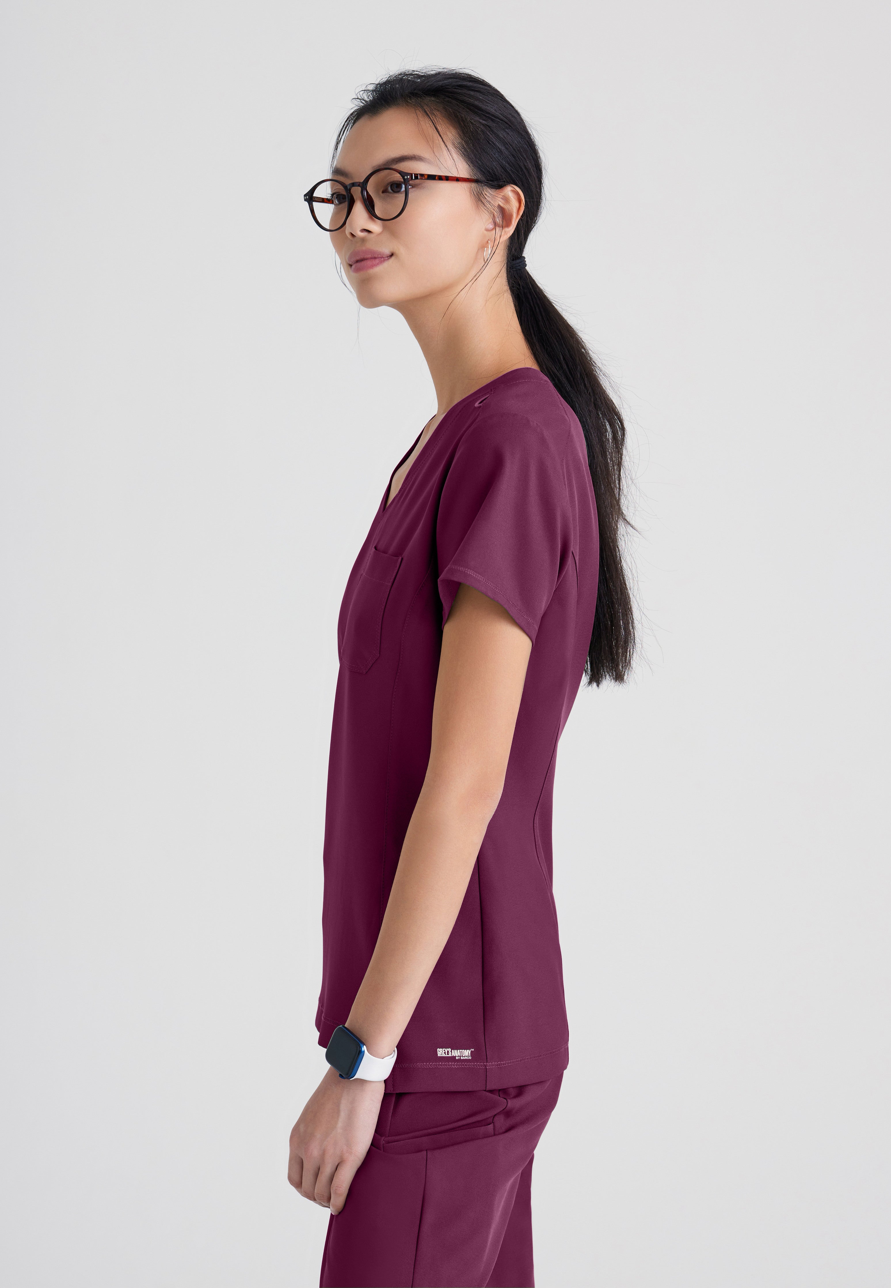 Side View of the Sway 1-Pocket Banded V-Neck Ciclo® Scrub Top in Wine from Grey's Anatomy™ by Barco Evolve