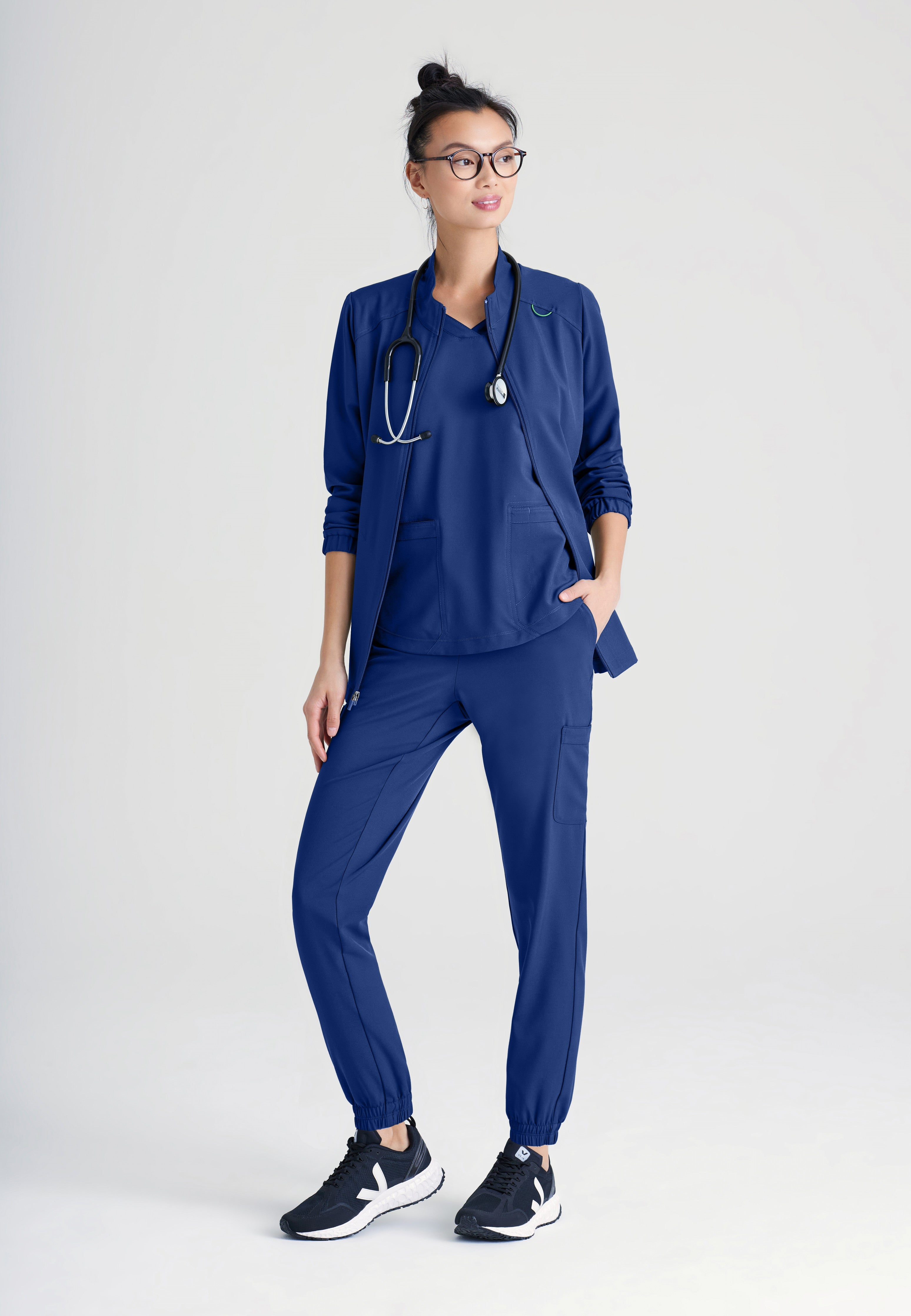 Full Body View of the Virtue 3-Pocket Stand-Up Collar Ciclo® Scrub Jacket in Indigo from Grey's Anatomy™ by Barco Evolve