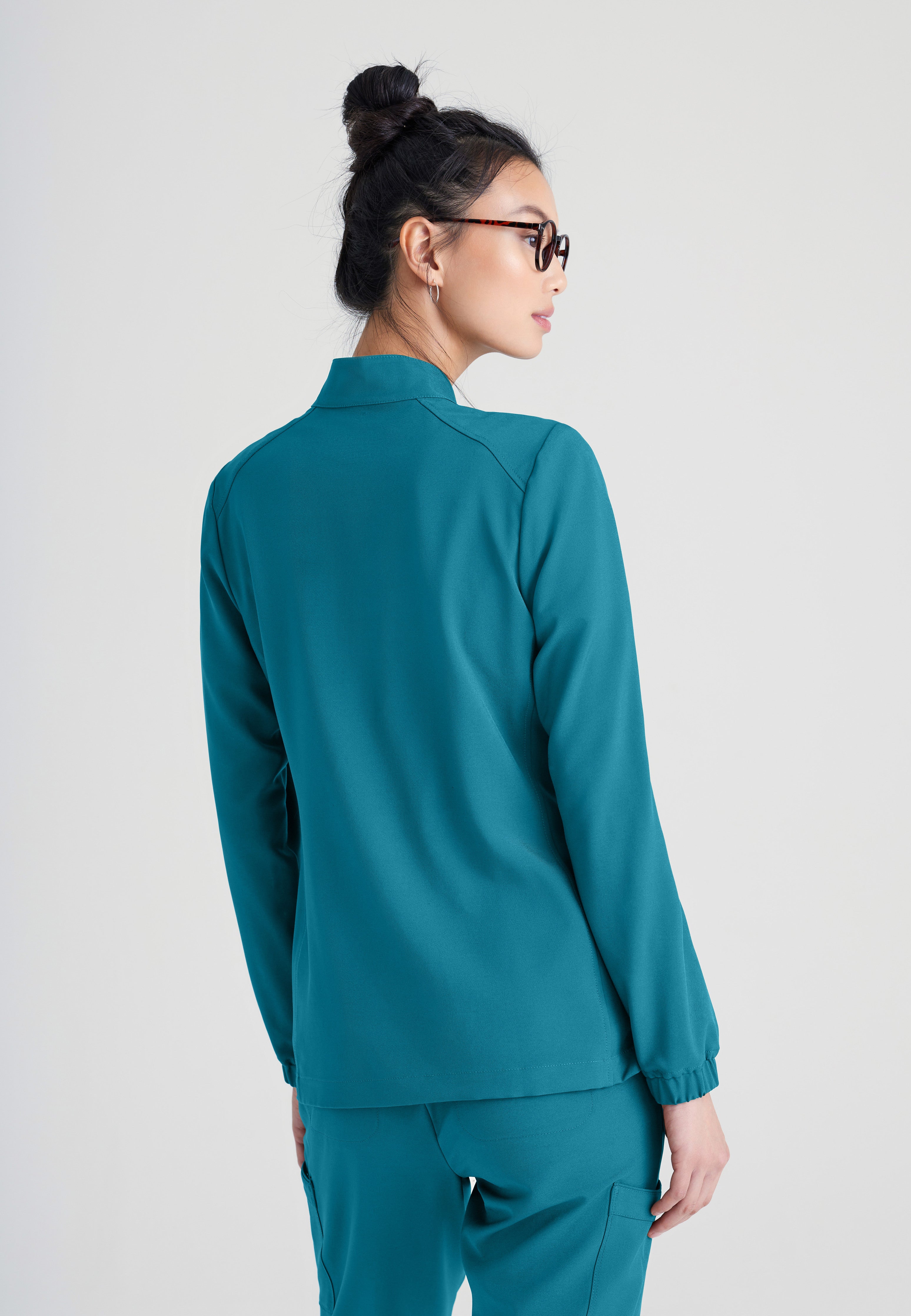 Back View of the Virtue 3-Pocket Stand-Up Collar Ciclo® Scrub Jacket in Bahama from Grey's Anatomy™ by Barco Evolve