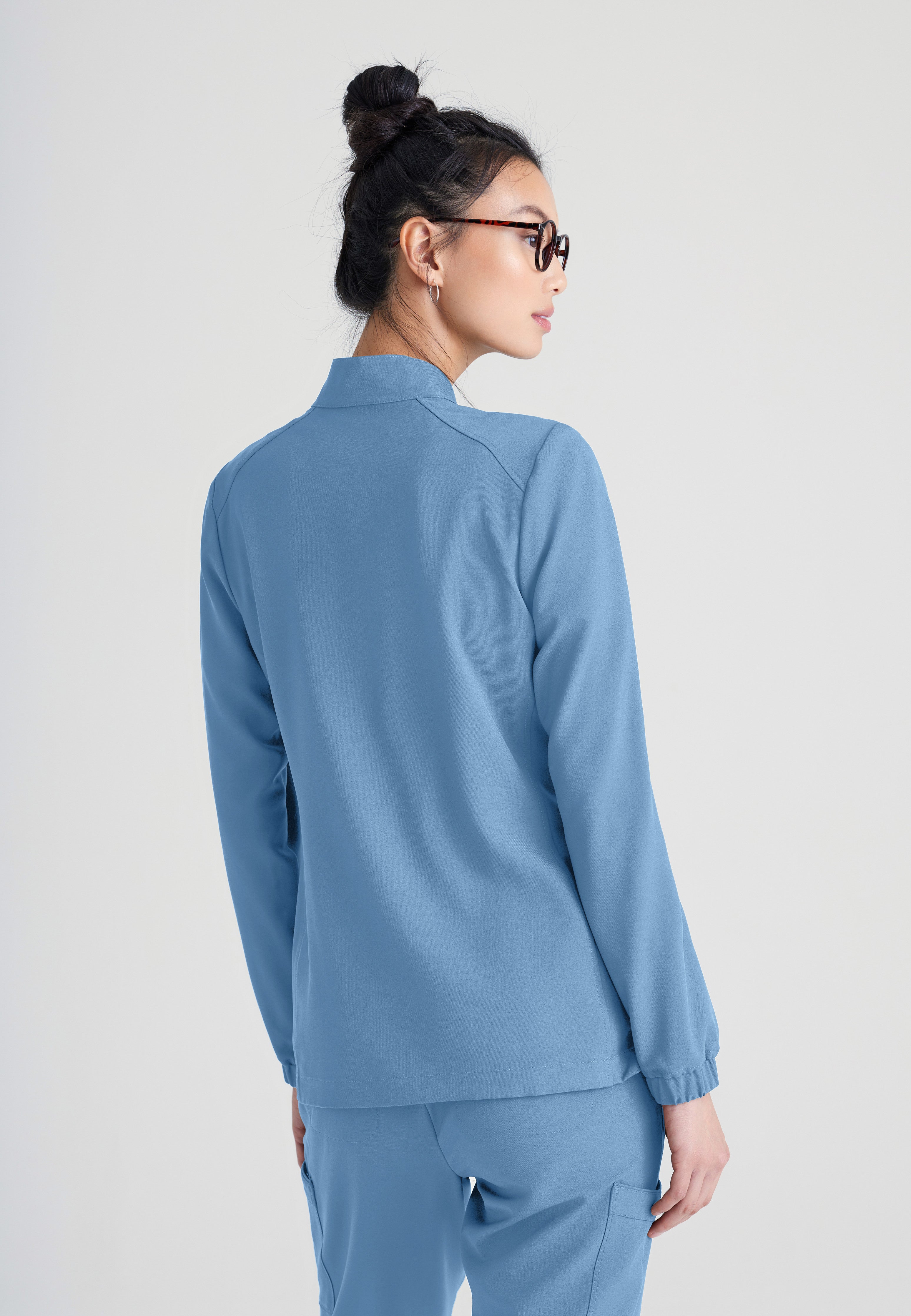 Back View of the Virtue 3-Pocket Stand-Up Collar Ciclo® Scrub Jacket in Ciel Blue from Grey's Anatomy™ by Barco Evolve