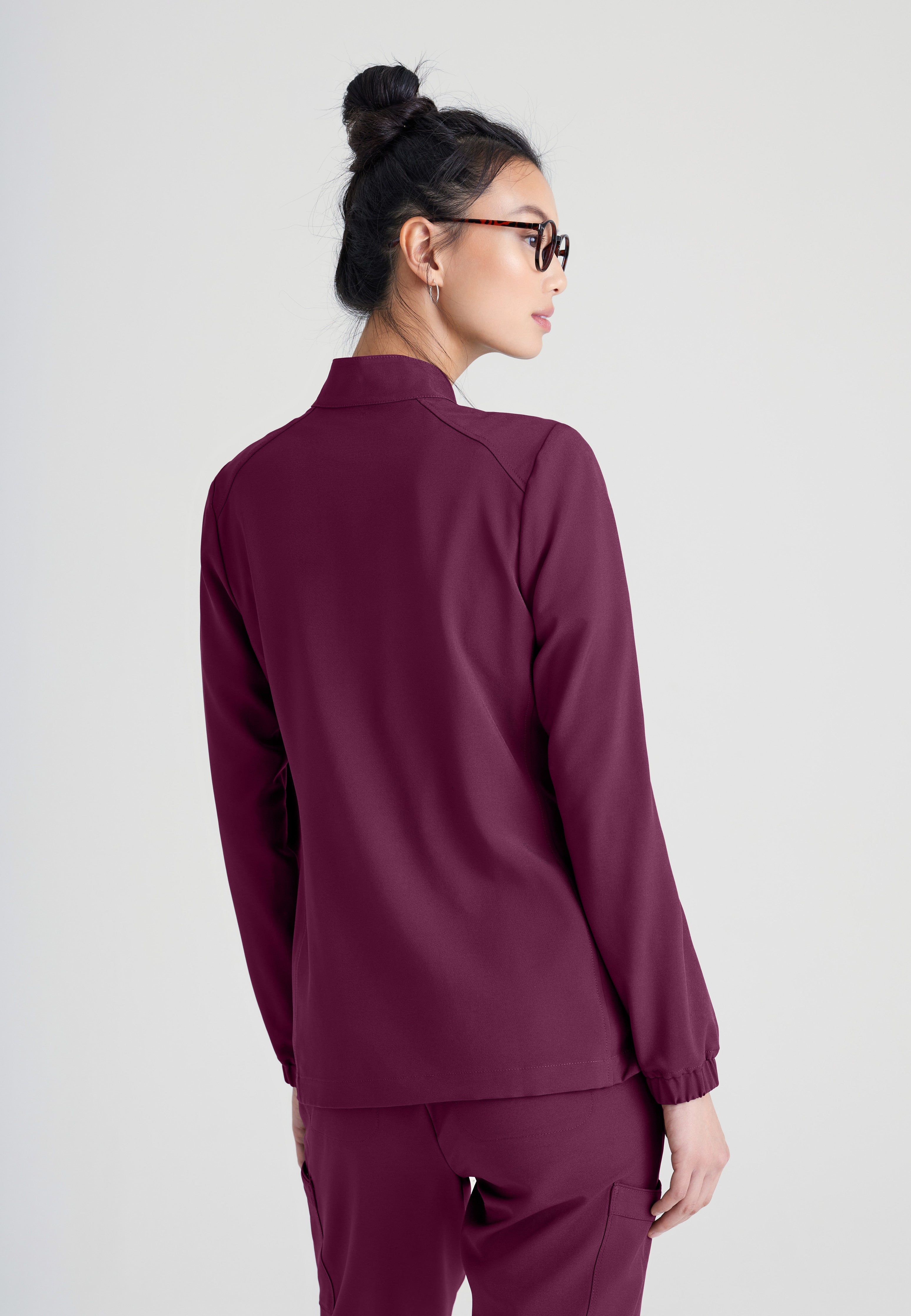 Back View of the Virtue 3-Pocket Stand-Up Collar Ciclo® Scrub Jacket in Wine from Grey's Anatomy™ by Barco Evolve